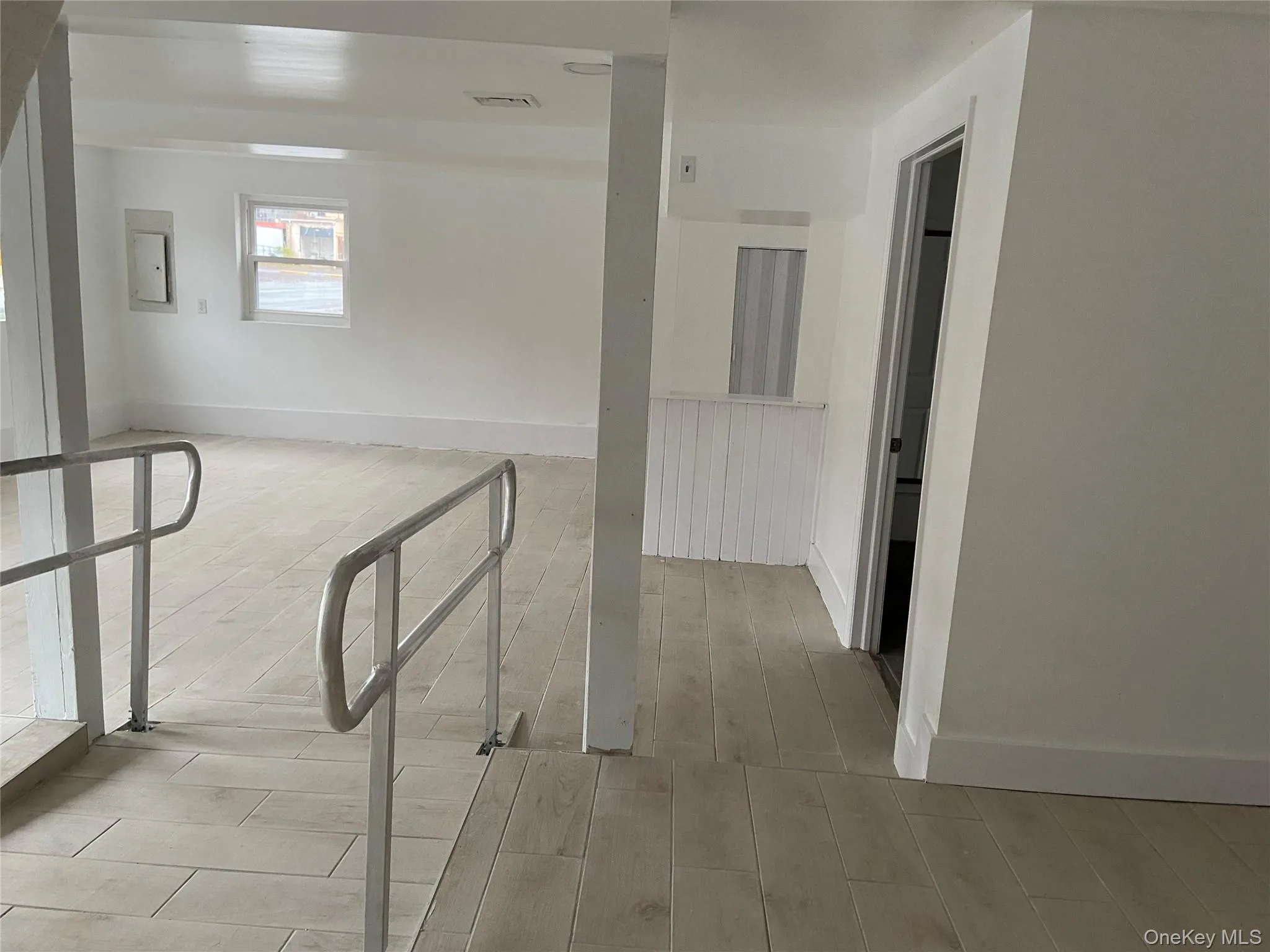 Hallway featuring light wood-style floors and electric panel Hallway featuring light wood-style floors and electric panel