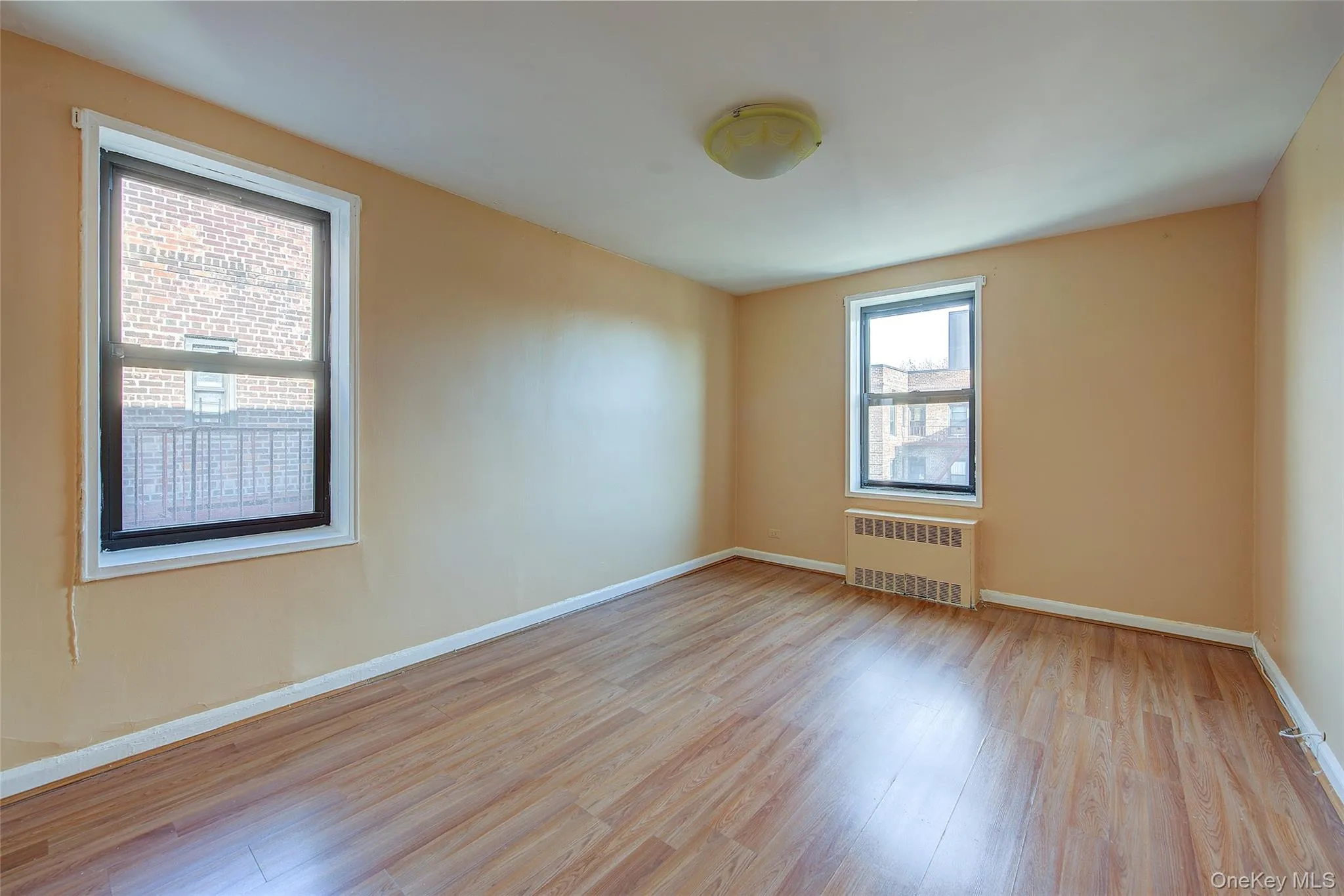Empty room with radiator and light wood finished floors Empty room with radiator and light wood finished floors