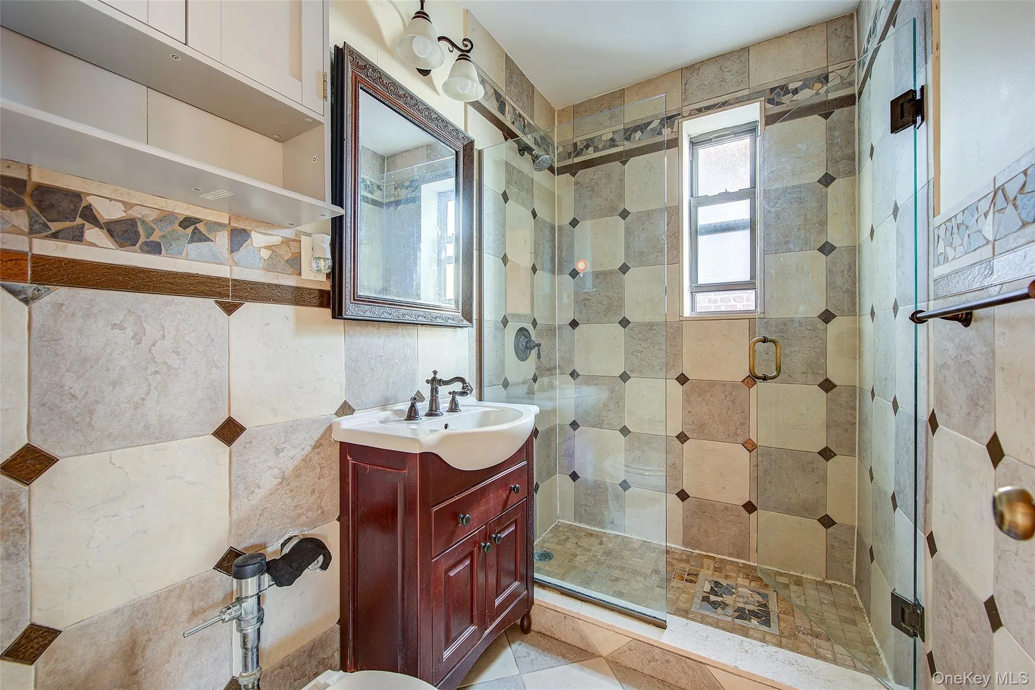 Bathroom featuring a stall shower, vanity, and tile walls Bathroom featuring a stall shower, vanity, and tile walls