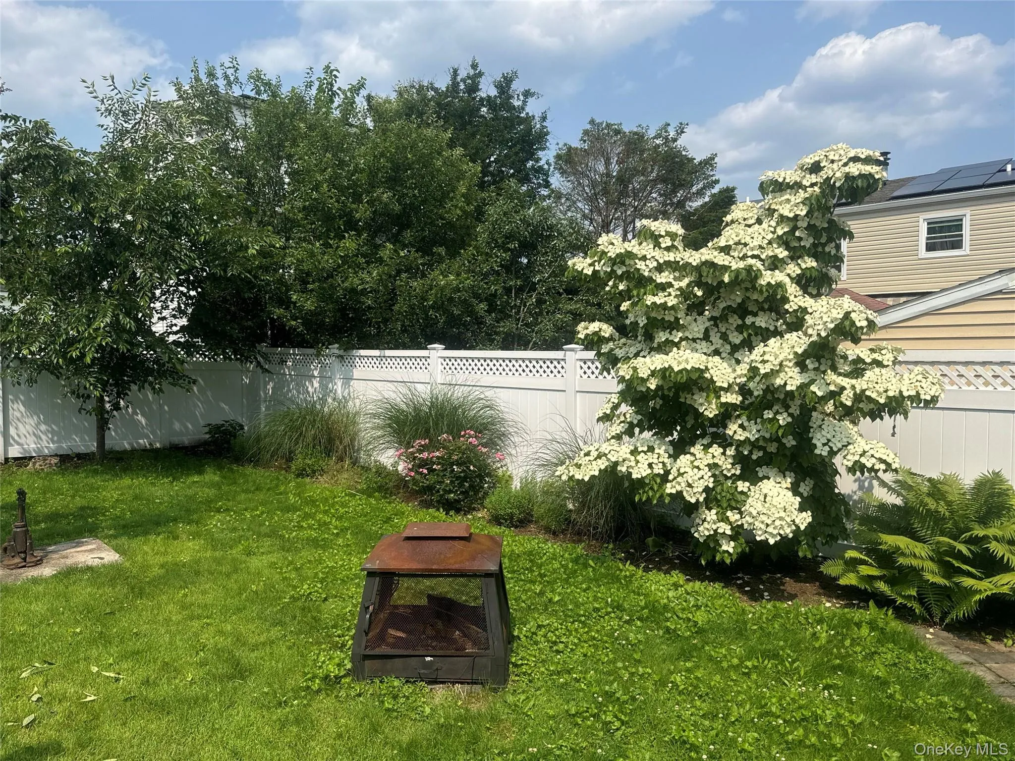 Fenced backyard with an outdoor fire pit Fenced backyard with an outdoor fire pit