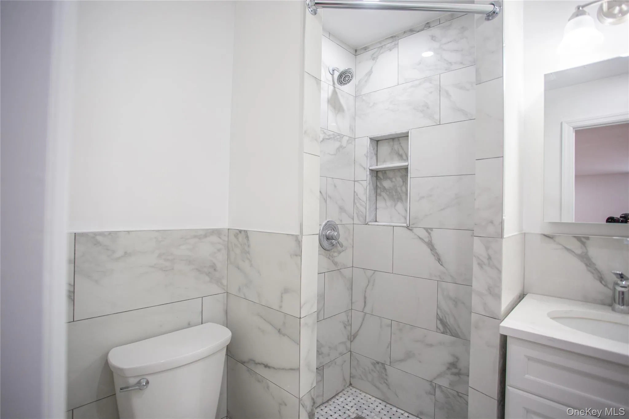 Full bathroom featuring vanity, a stall shower, and tile walls Full bathroom featuring vanity, a stall shower, and tile walls