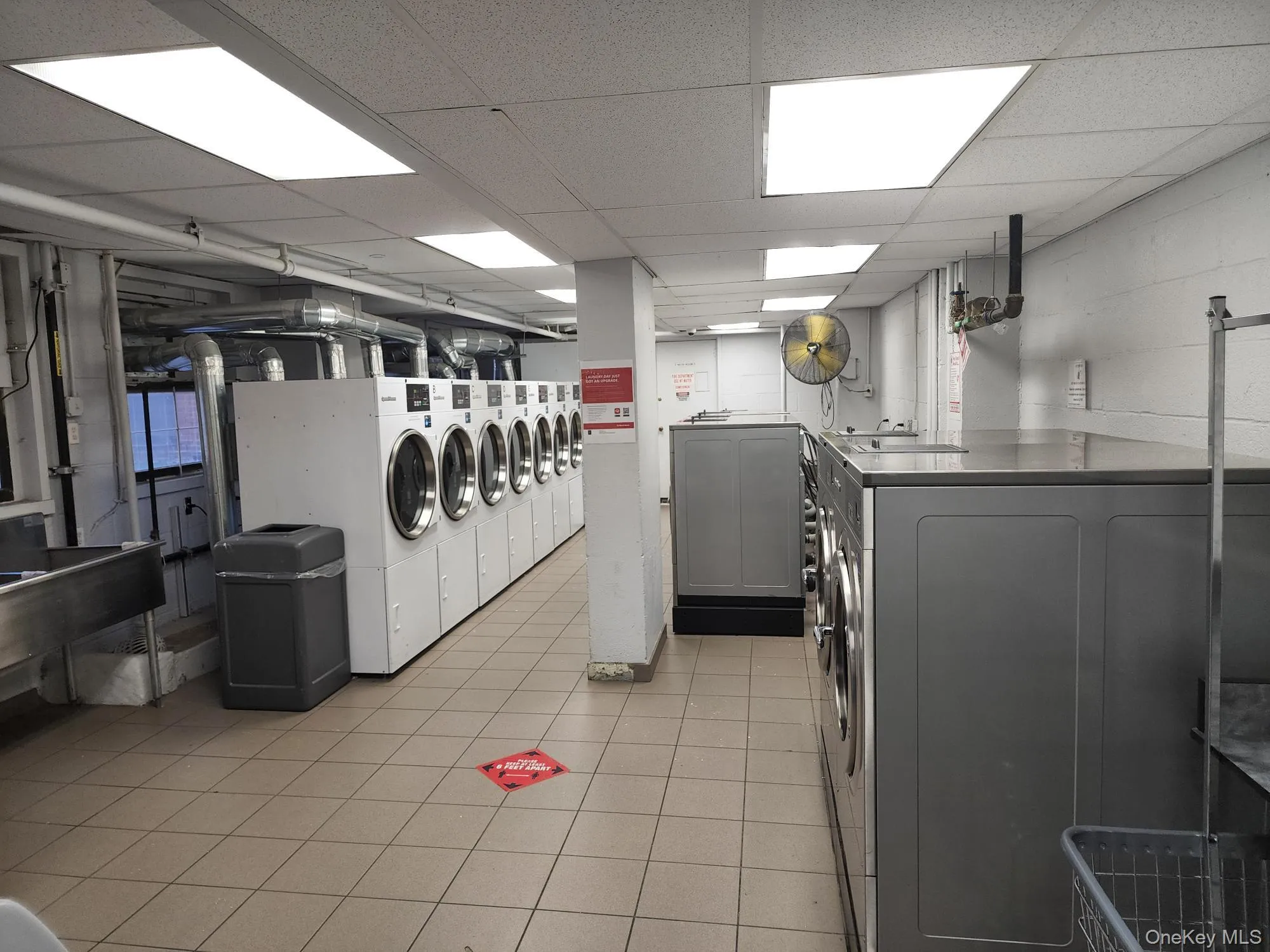 Community laundry with washer and dryer and a paneled ceiling Community laundry with washer and dryer and a paneled ceiling