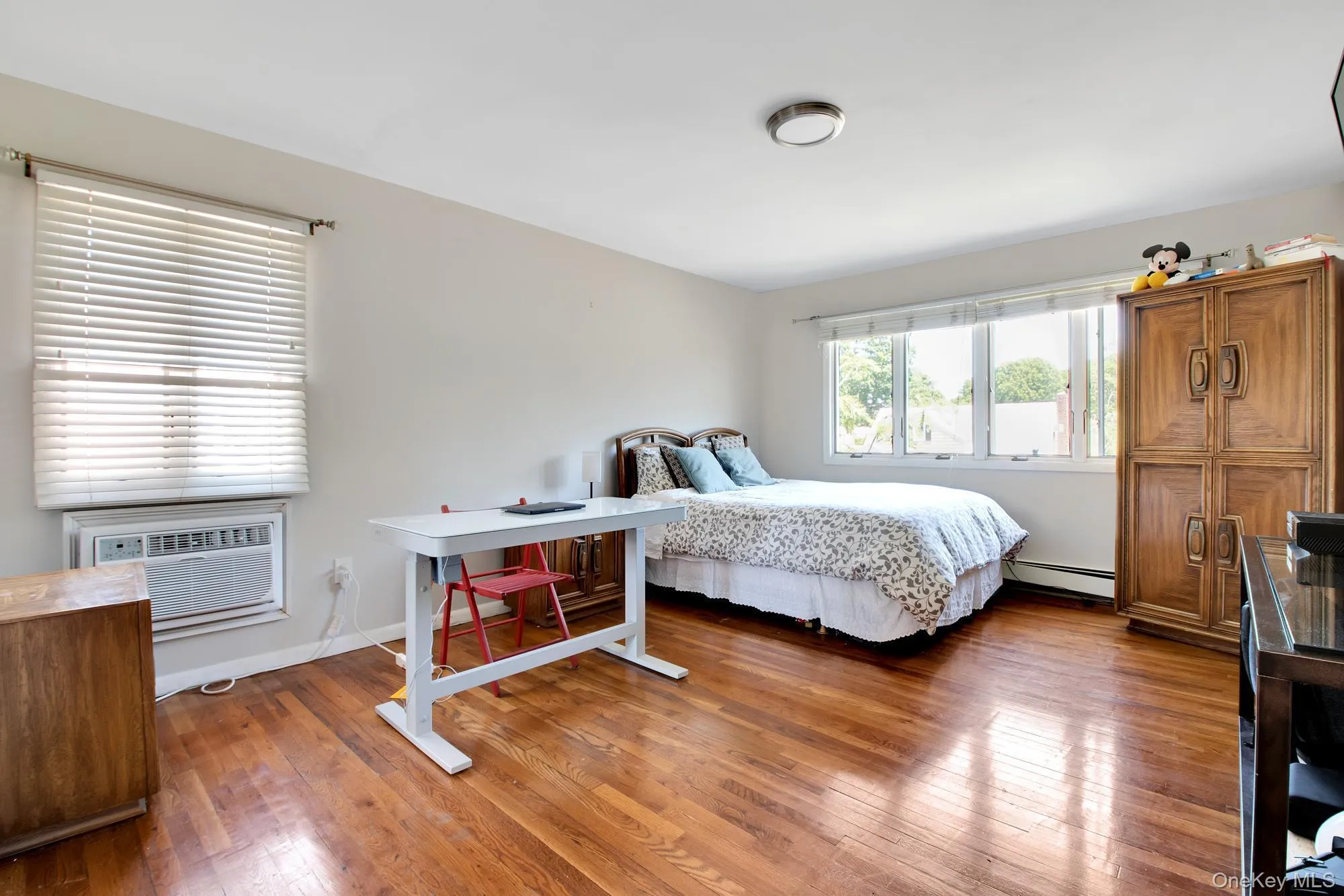 Bedroom featuring light wood finished floors and baseboard heating Bedroom featuring light wood finished floors and baseboard heating