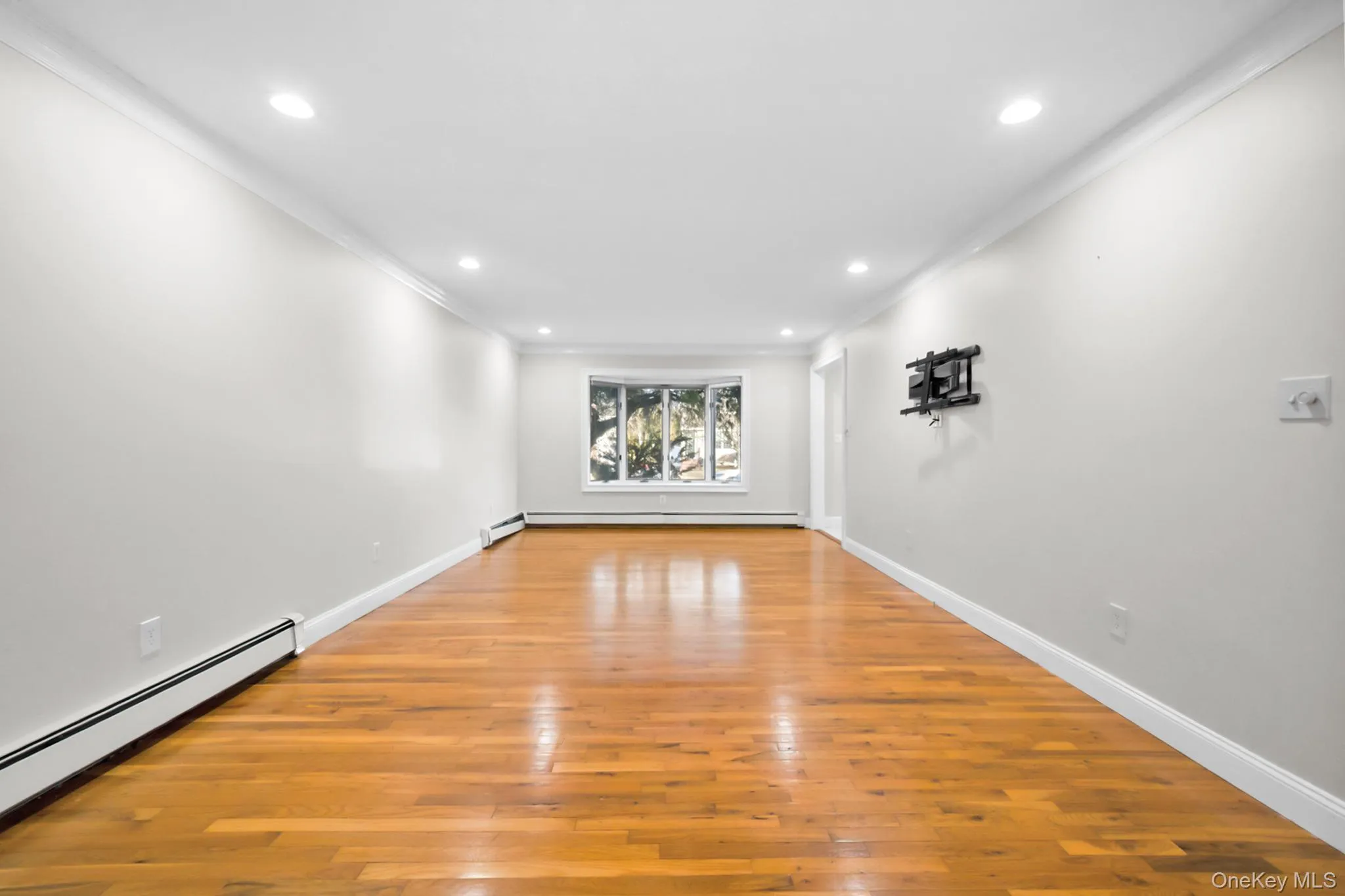 Spare room with light wood-style flooring, a baseboard radiator, crown molding, and recessed lighting Spare room with light wood-style flooring, a baseboard radiator, crown molding, and recessed lighting