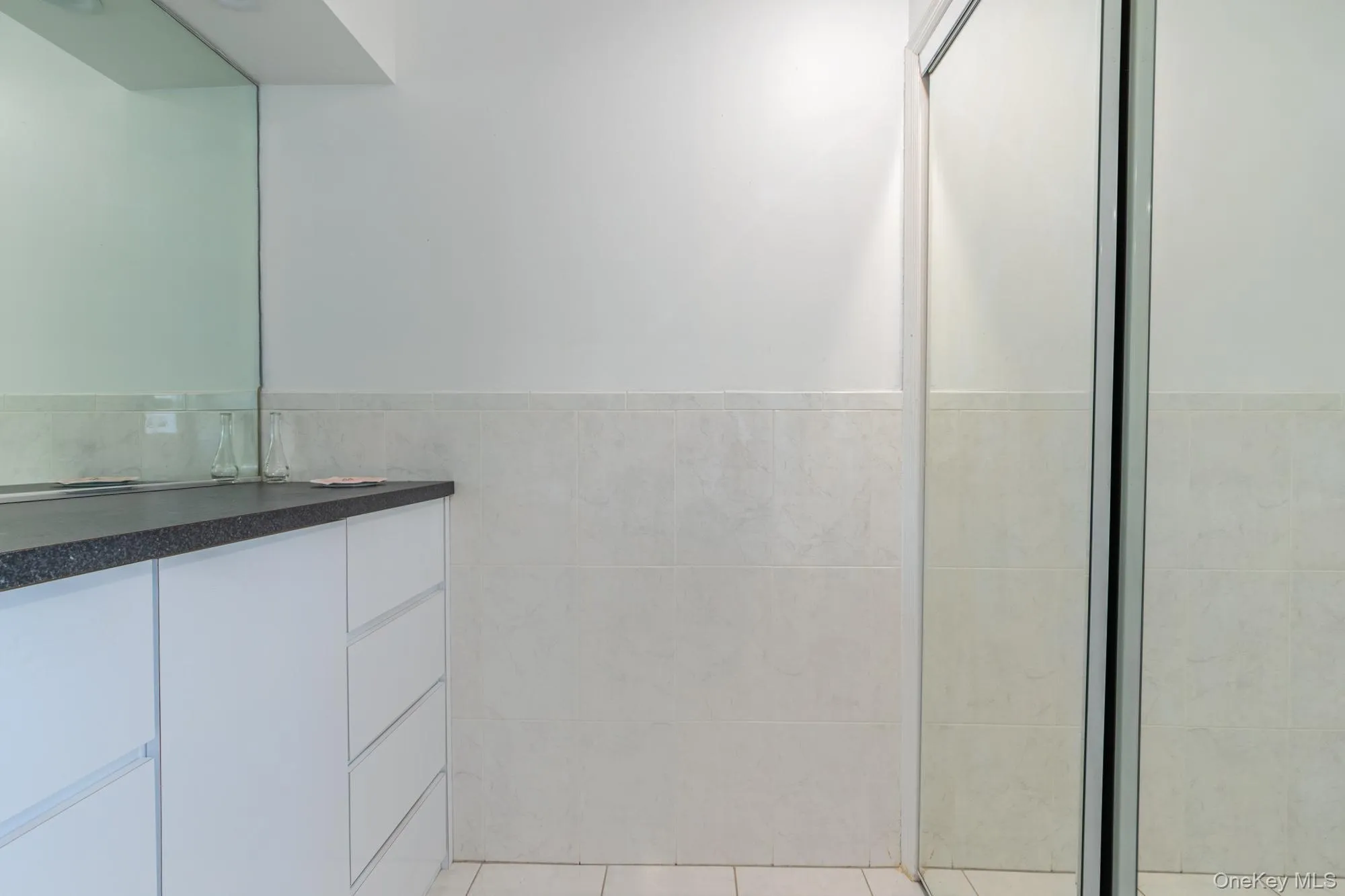 Bathroom featuring vanity and tile walls Bathroom featuring vanity and tile walls
