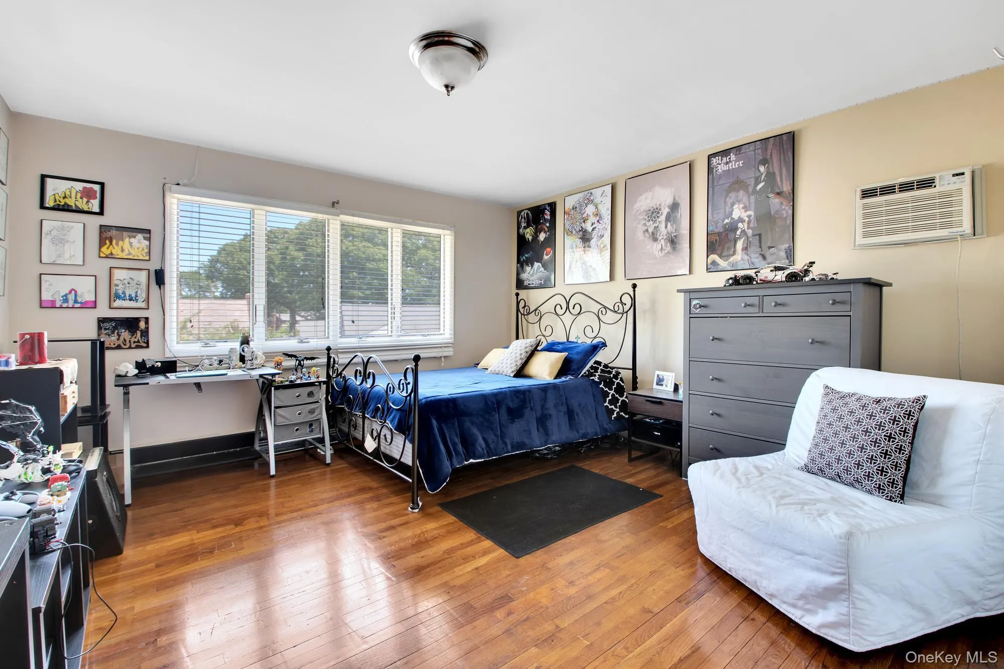 Bedroom with hardwood / wood-style floors and an AC wall unit Bedroom with hardwood / wood-style floors and an AC wall unit