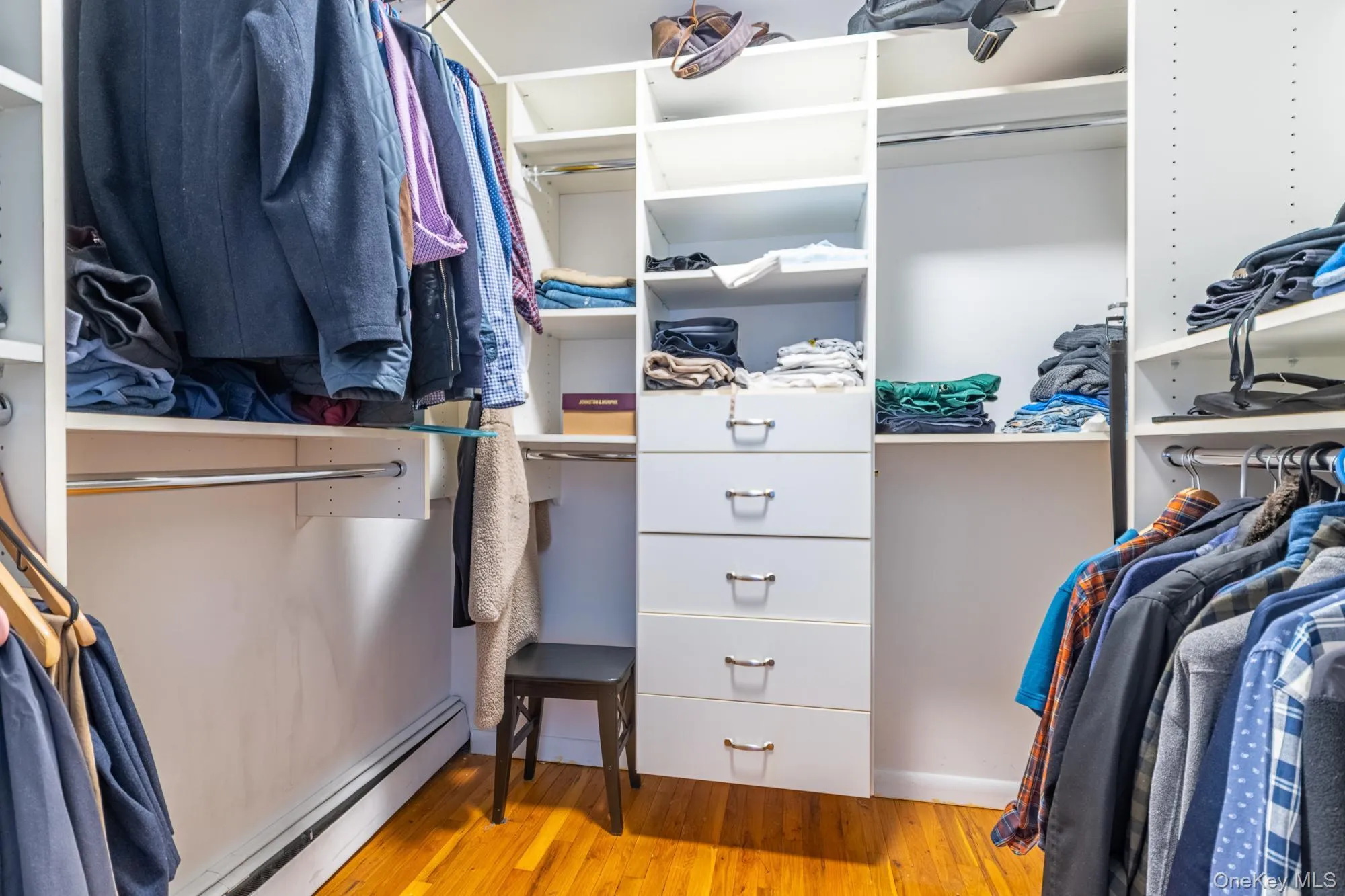 Spacious closet featuring baseboard heating and light wood-style flooring Spacious closet featuring baseboard heating and light wood-style flooring