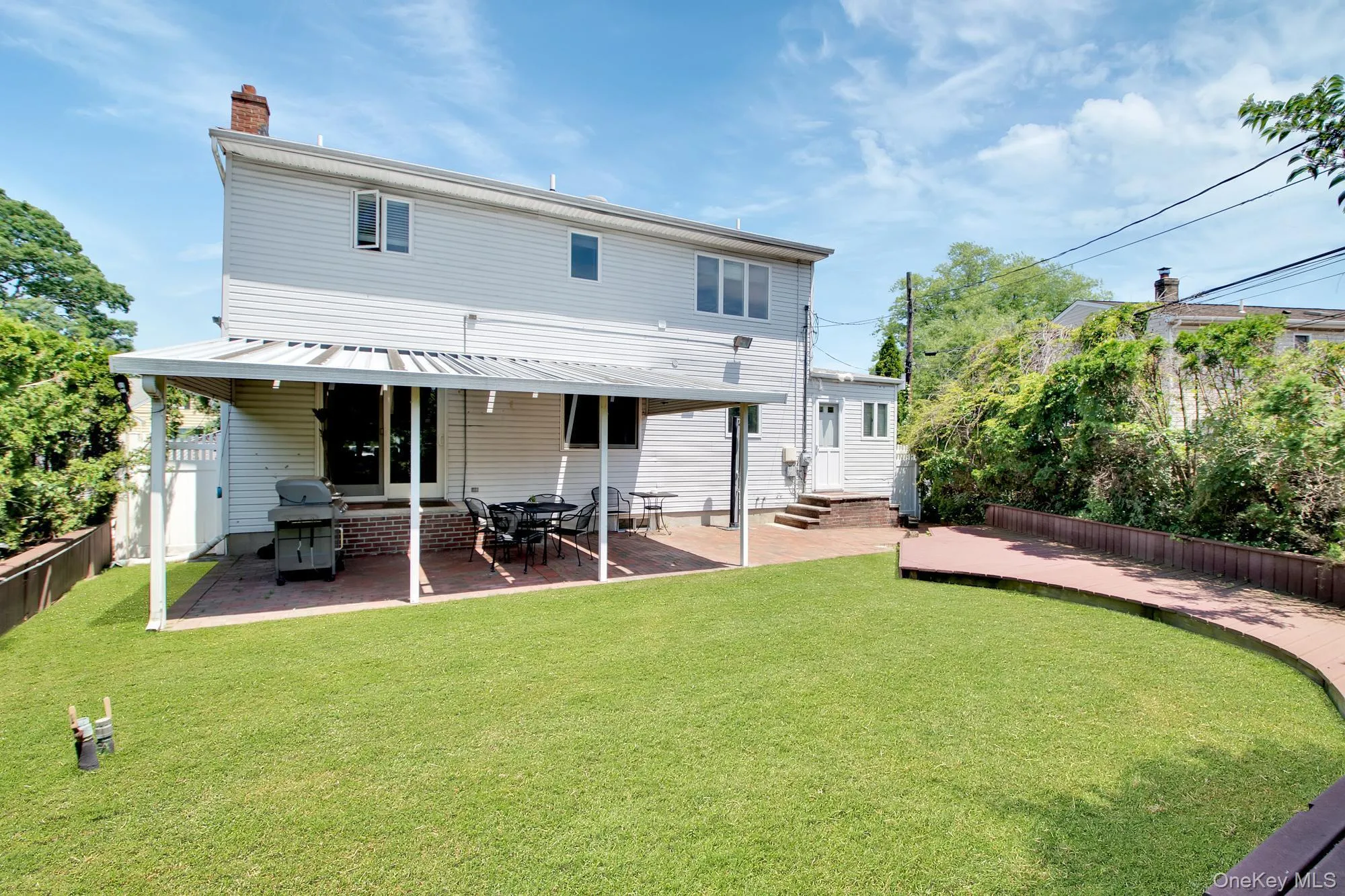Back of house featuring a patio area, a chimney, and entry steps Back of house featuring a patio area, a chimney, and entry steps