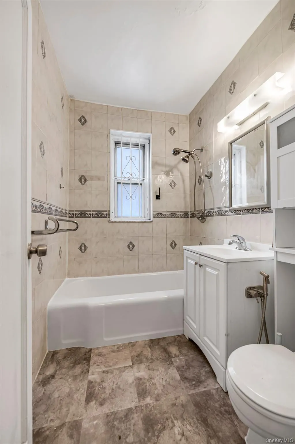 Bathroom with vanity, shower combination, and tile walls Bathroom with vanity, shower combination, and tile walls