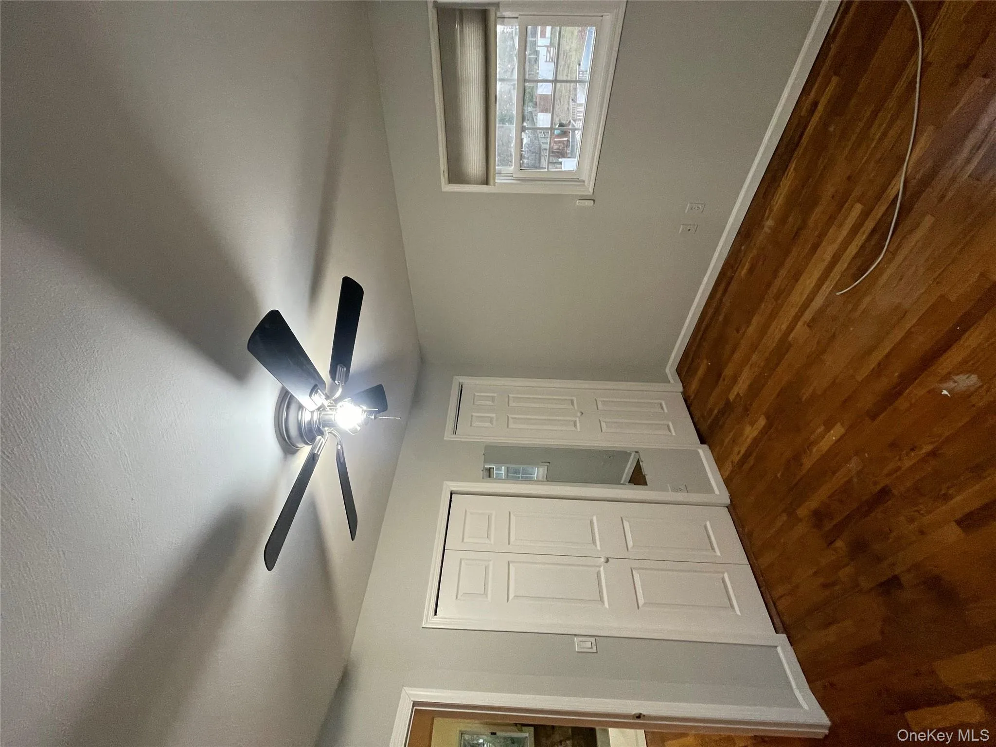 Unfurnished bedroom with a closet, dark wood-style flooring, and a ceiling fan Unfurnished bedroom with a closet, dark wood-style flooring, and a ceiling fan