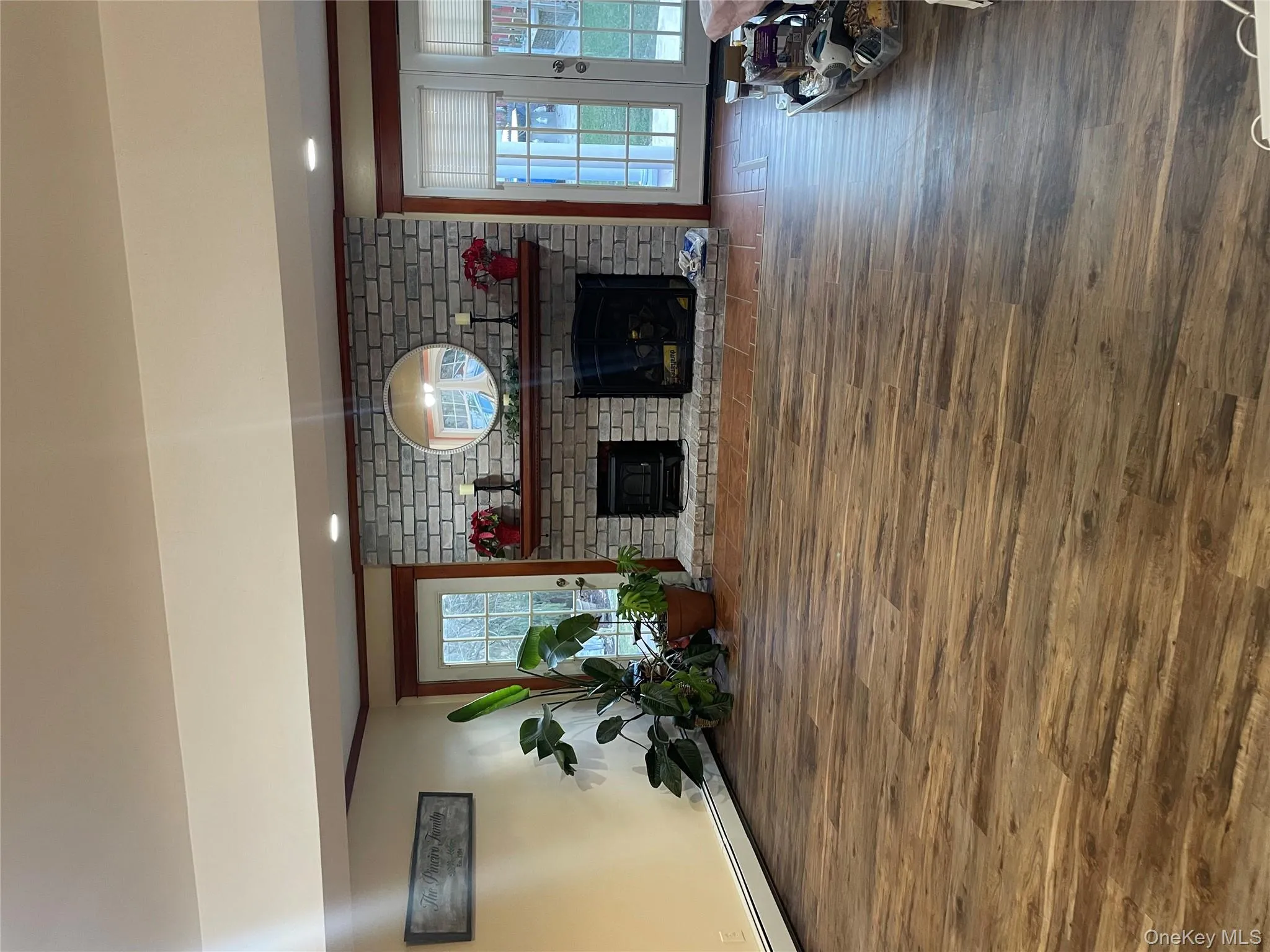 Living room with a fireplace, wood finished floors, baseboard heating, crown molding, and recessed lighting Living room with a fireplace, wood finished floors, baseboard heating, crown molding, and recessed lighting