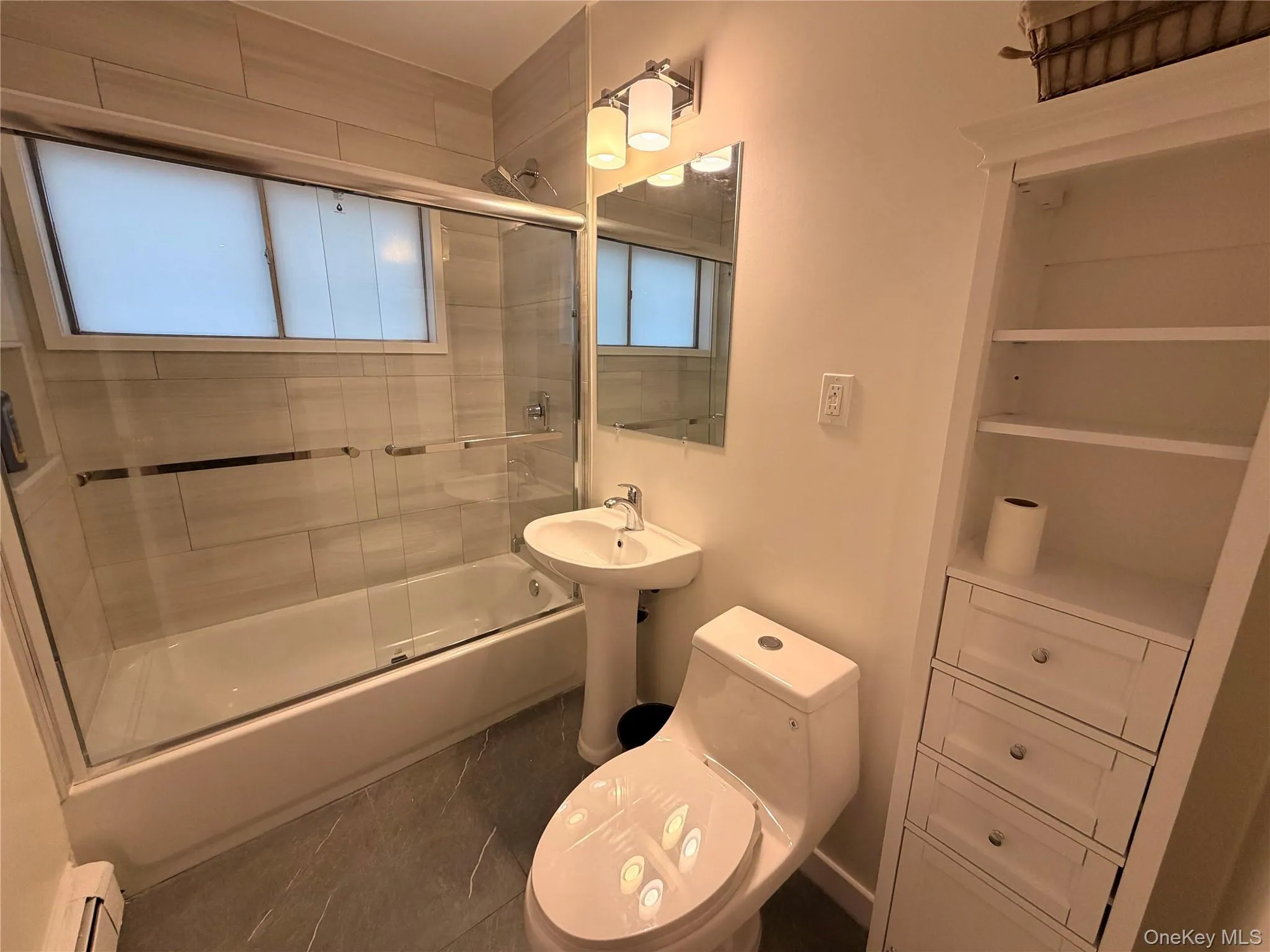 Full bathroom with shower / bath combination with glass door, tile patterned flooring, and baseboard heating Full bathroom with shower / bath combination with glass door, tile patterned flooring, and baseboard heating