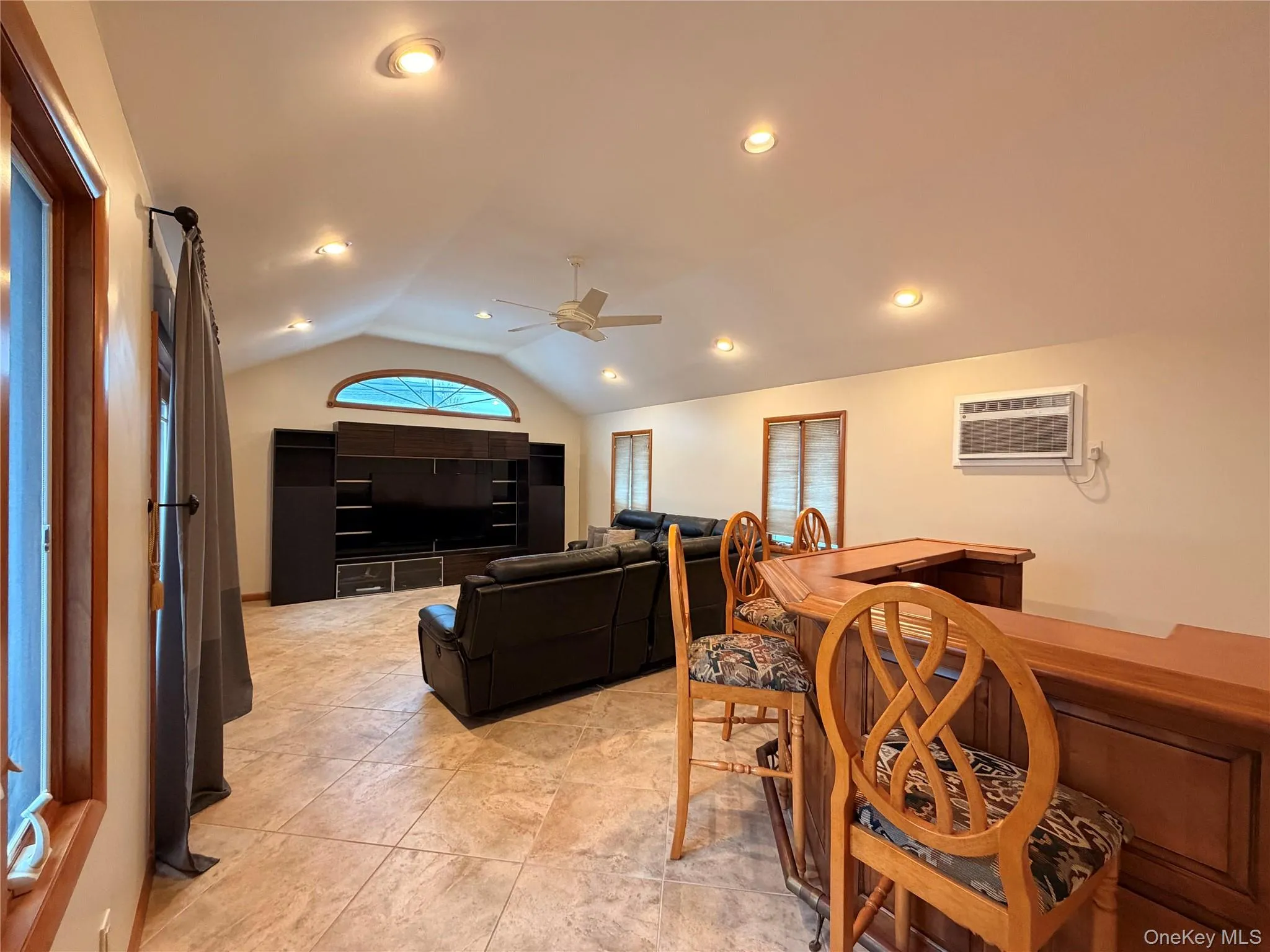 Dining space with lofted ceiling, ceiling fan, a wall mounted AC, and recessed lighting Dining space with lofted ceiling, ceiling fan, a wall mounted AC, and recessed lighting
