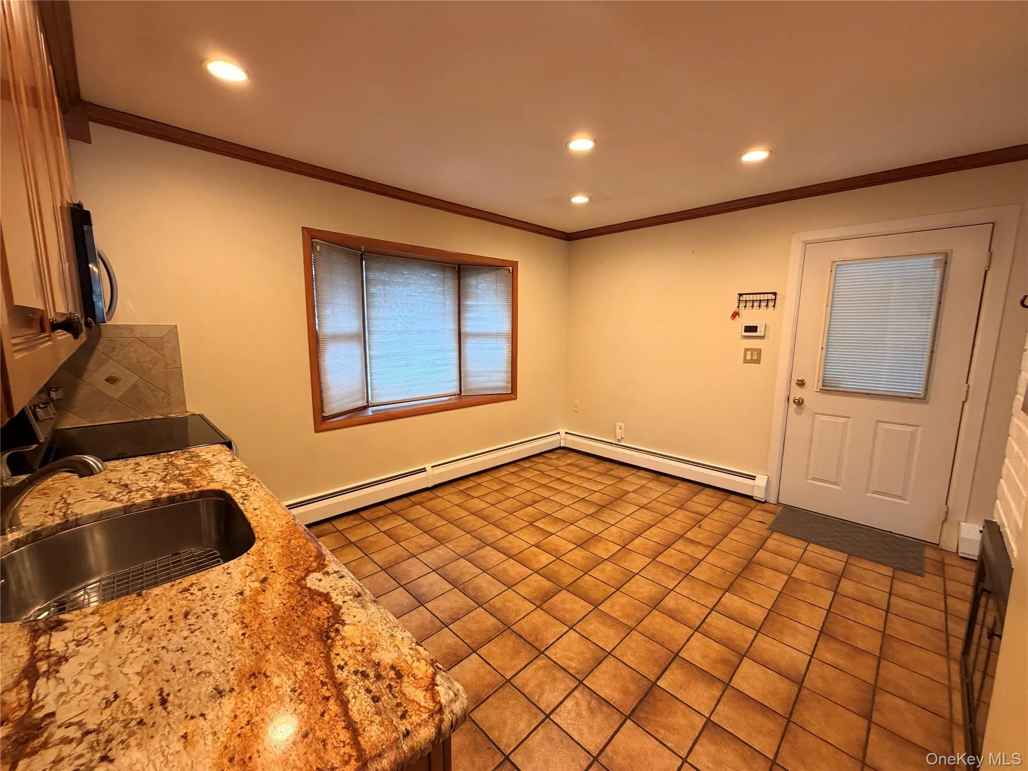 Kitchen featuring crown molding, range with electric cooktop, recessed lighting, light stone counters, and black microwave Kitchen featuring crown molding, range with electric cooktop, recessed lighting, light stone counters, and black microwave