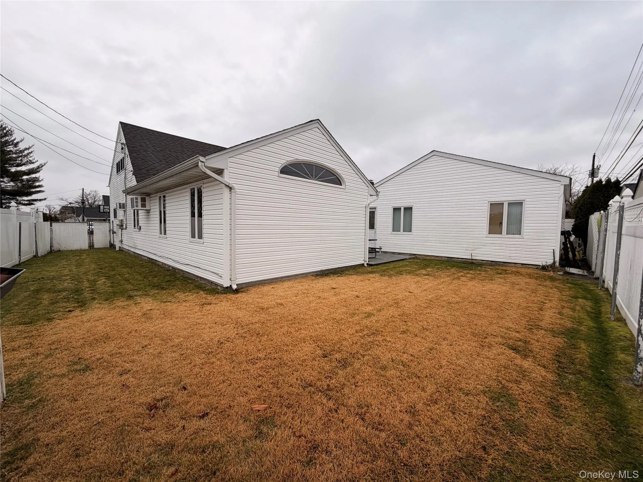 Rear view of property with a fenced backyard and roof with shingles Rear view of property with a fenced backyard and roof with shingles
