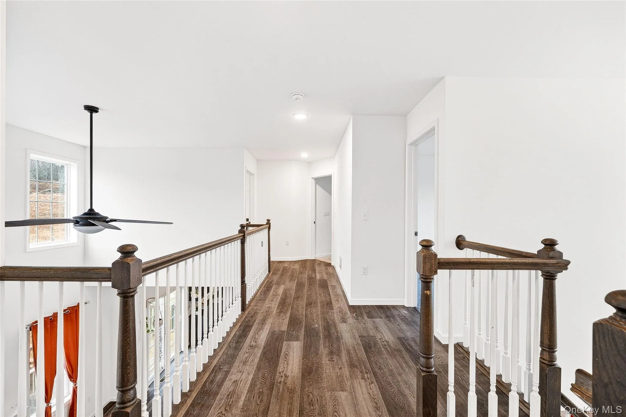 Corridor featuring dark wood finished floors, an upstairs landing, and recessed lighting Corridor featuring dark wood finished floors, an upstairs landing, and recessed lighting