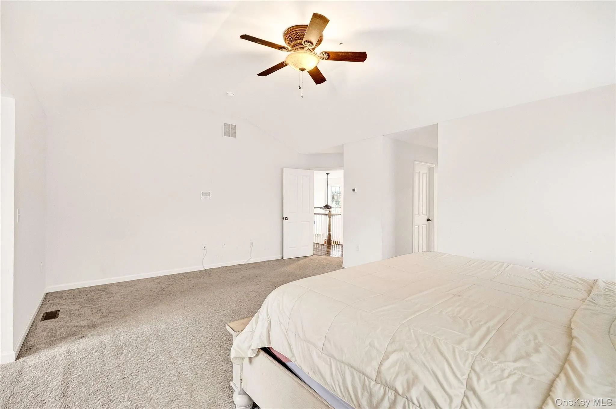 Carpeted bedroom with ceiling fan and lofted ceiling Carpeted bedroom with ceiling fan and lofted ceiling