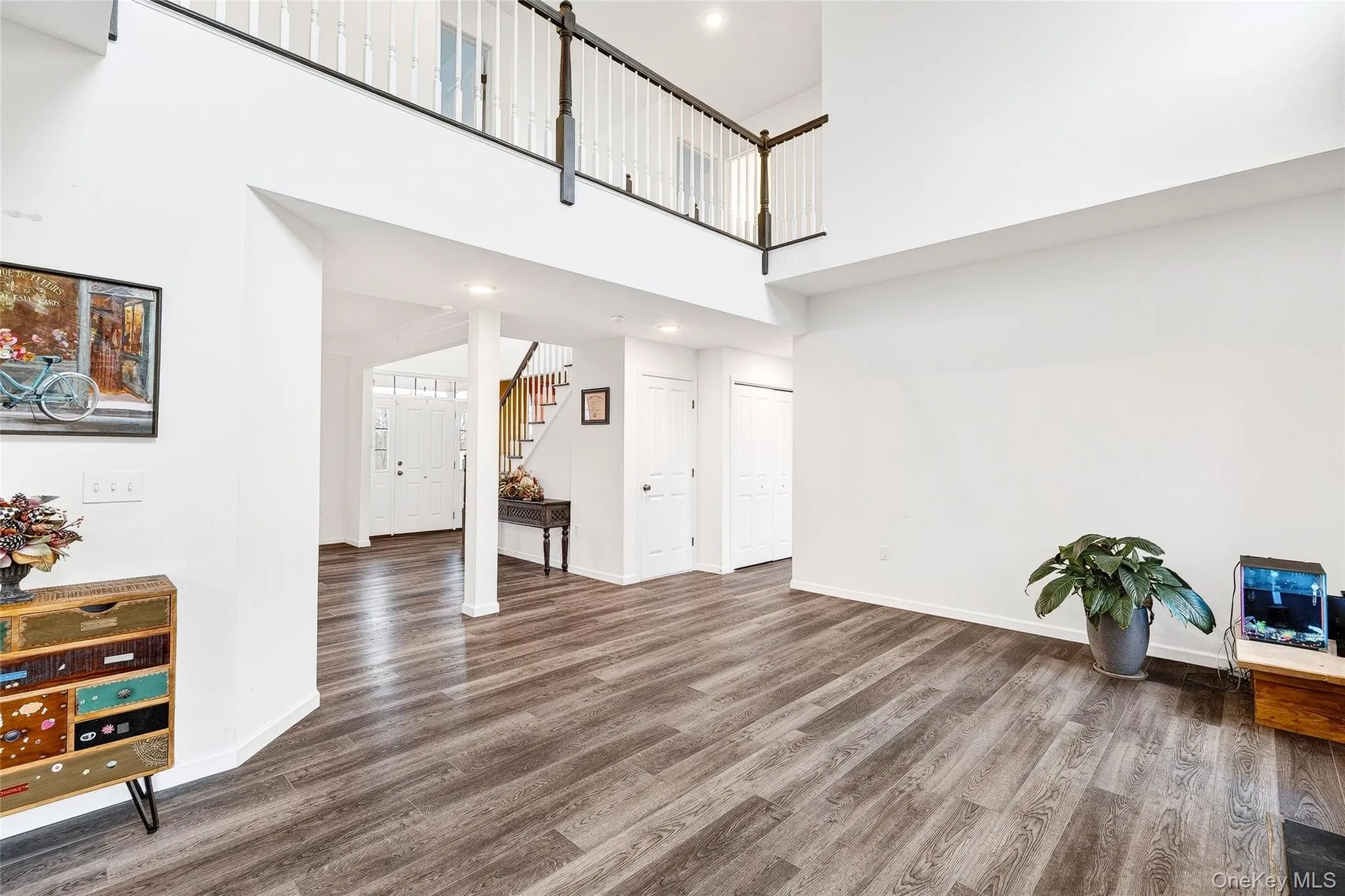 Living room with a high ceiling, wood finished floors, stairs, and recessed lighting Living room with a high ceiling, wood finished floors, stairs, and recessed lighting