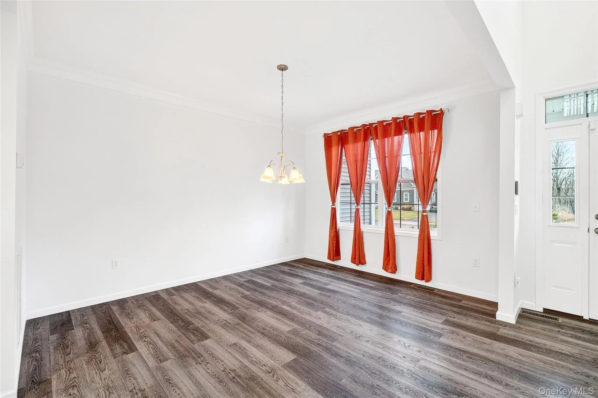 Unfurnished dining area featuring crown molding, dark wood-style floors, and a chandelier Unfurnished dining area featuring crown molding, dark wood-style floors, and a chandelier