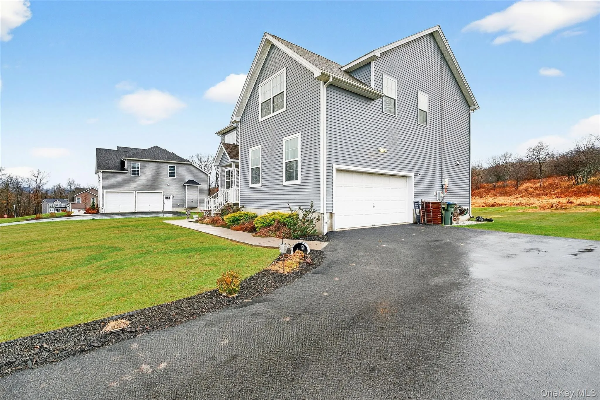 View of side of home with a lawn, driveway, and a garage View of side of home with a lawn, driveway, and a garage