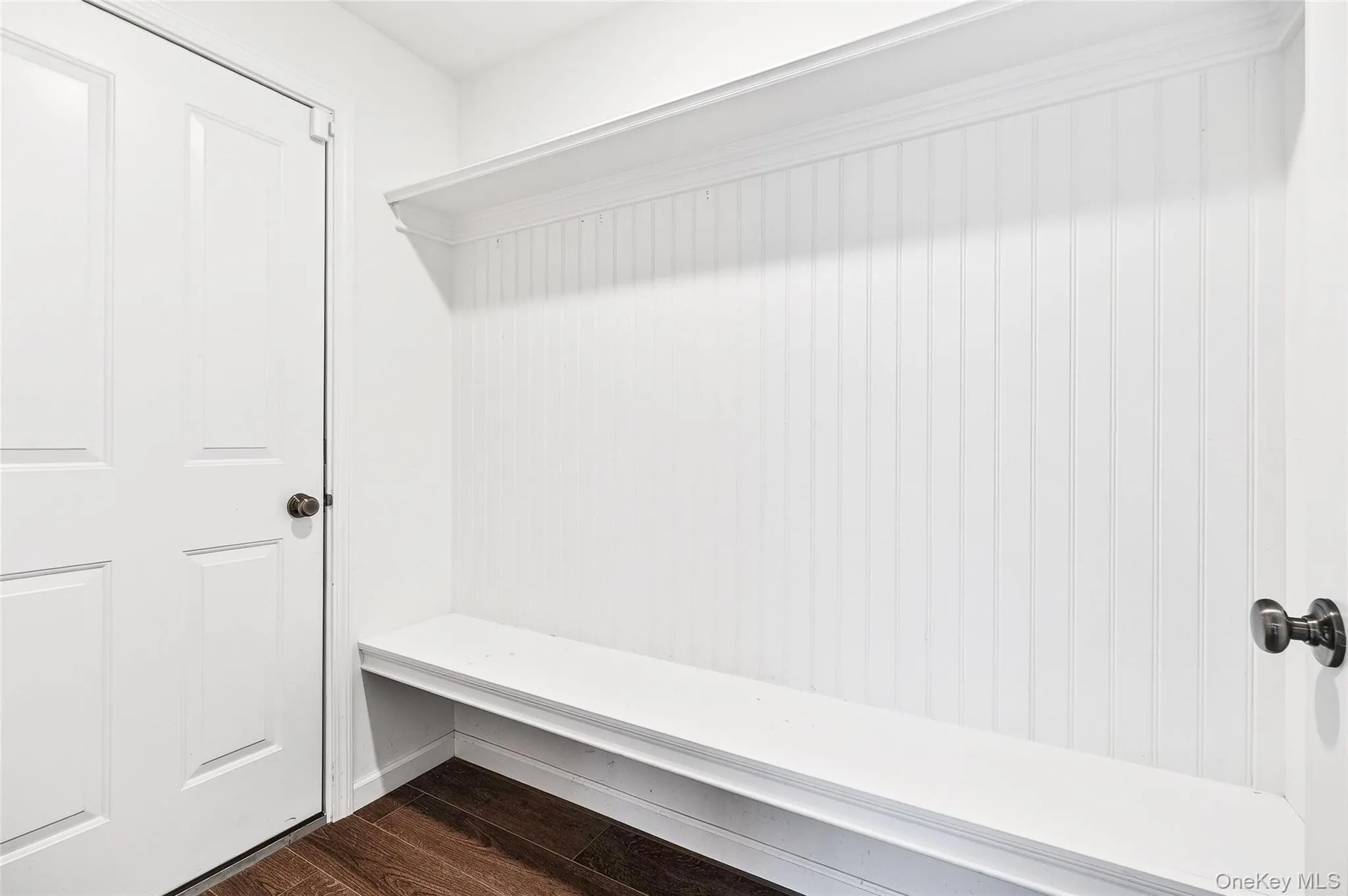 Mudroom featuring dark wood-type flooring and baseboards Mudroom featuring dark wood-type flooring and baseboards