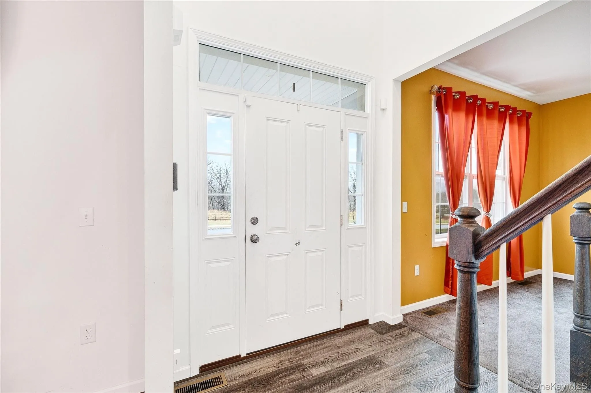 Entryway featuring wood finished floors, plenty of natural light, and stairs Entryway featuring wood finished floors, plenty of natural light, and stairs