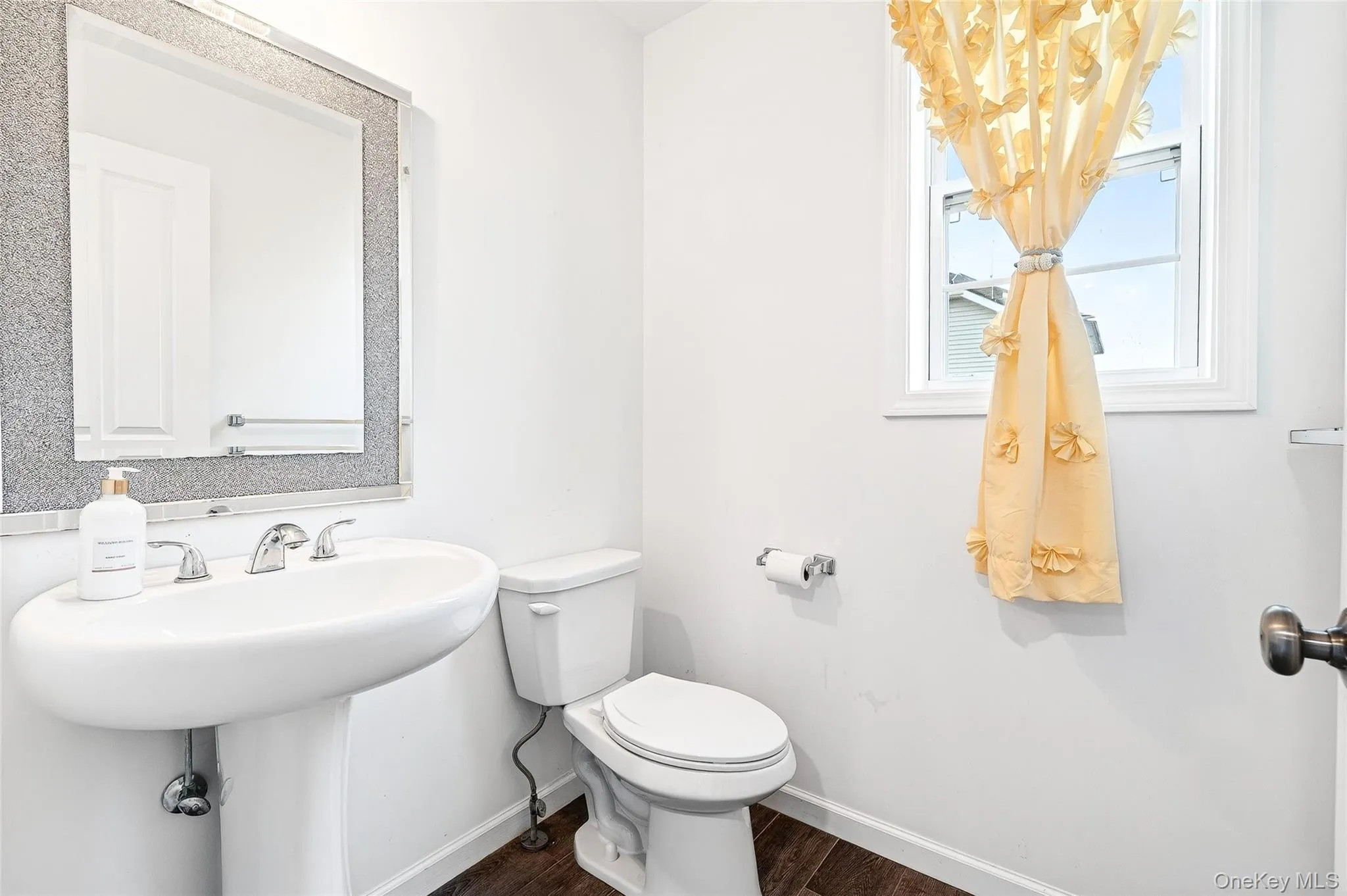 Half bath with baseboards and dark wood finished floors Half bath with baseboards and dark wood finished floors