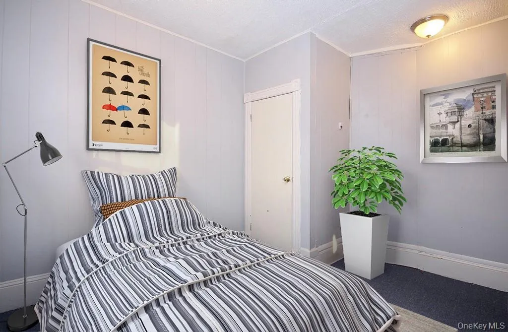 Virtually Staged - Carpeted bedroom with baseboards and a textured ceiling Virtually Staged - Carpeted bedroom with baseboards and a textured ceiling