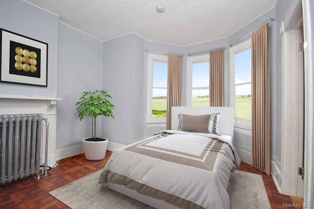 Virtually Staged - Bedroom with radiator heating unit and a fireplace Virtually Staged - Bedroom with radiator heating unit and a fireplace