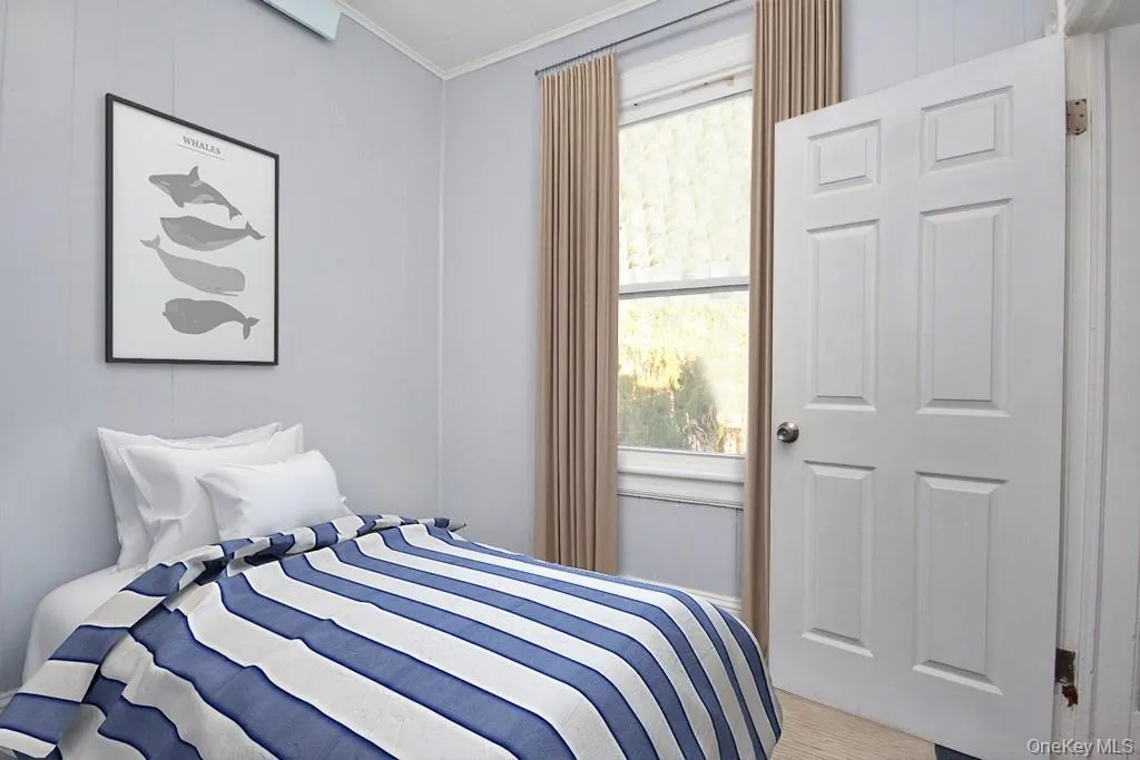 Virtually Staged - Bedroom with crown molding and multiple windows Virtually Staged - Bedroom with crown molding and multiple windows