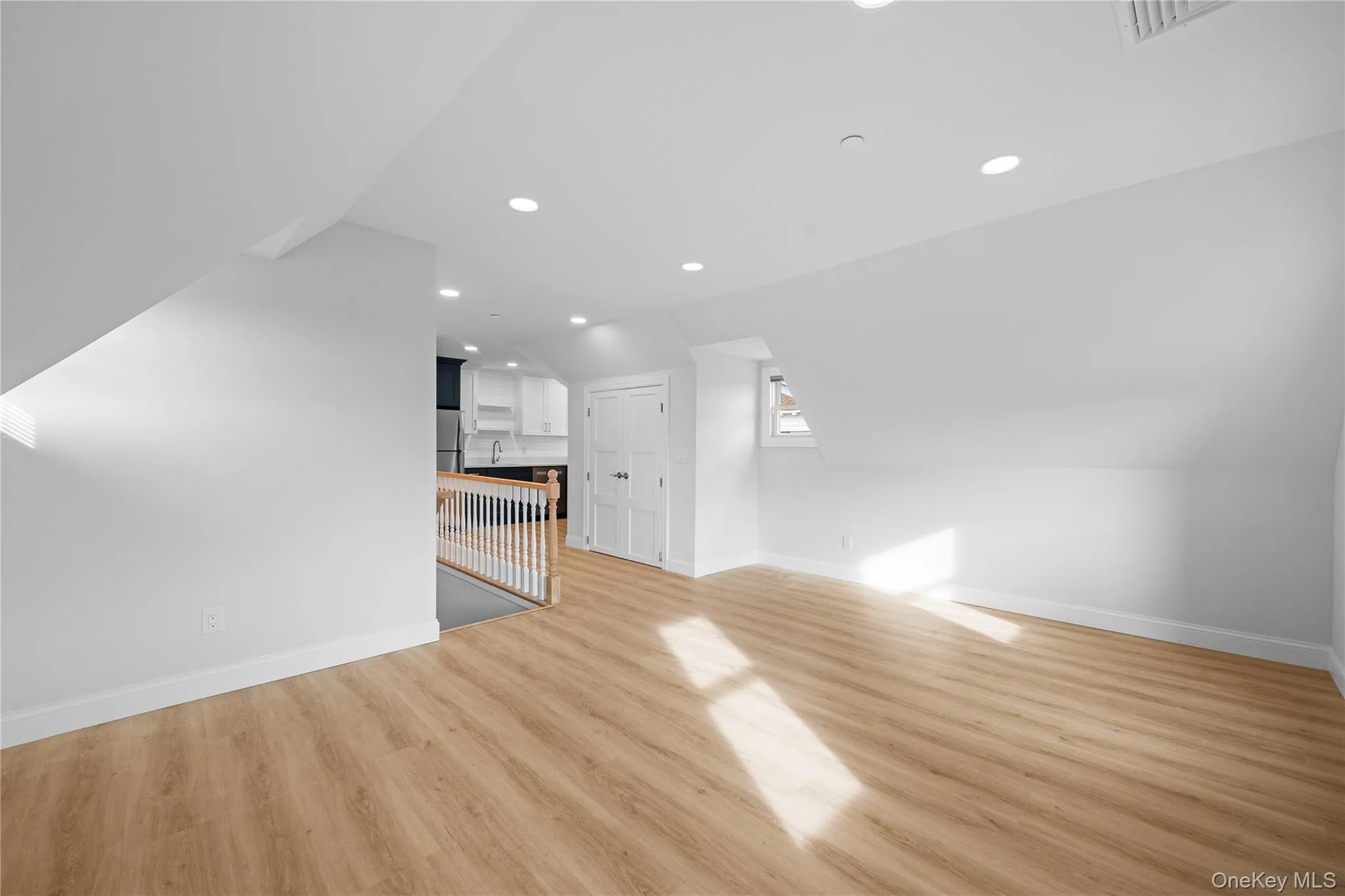 Unfurnished living room featuring recessed lighting, lofted ceiling, and light wood-style floors Unfurnished living room featuring recessed lighting, lofted ceiling, and light wood-style floors