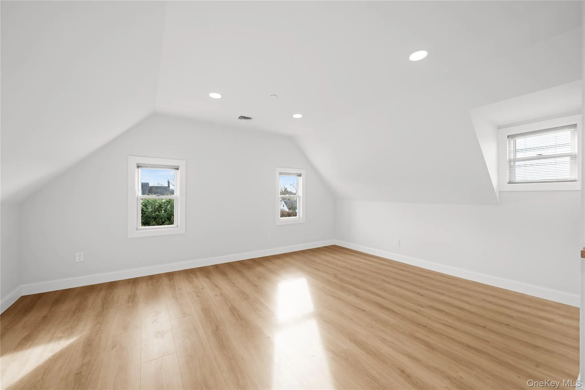 Additional living space with light wood finished floors, lofted ceiling, and recessed lighting Additional living space with light wood finished floors, lofted ceiling, and recessed lighting