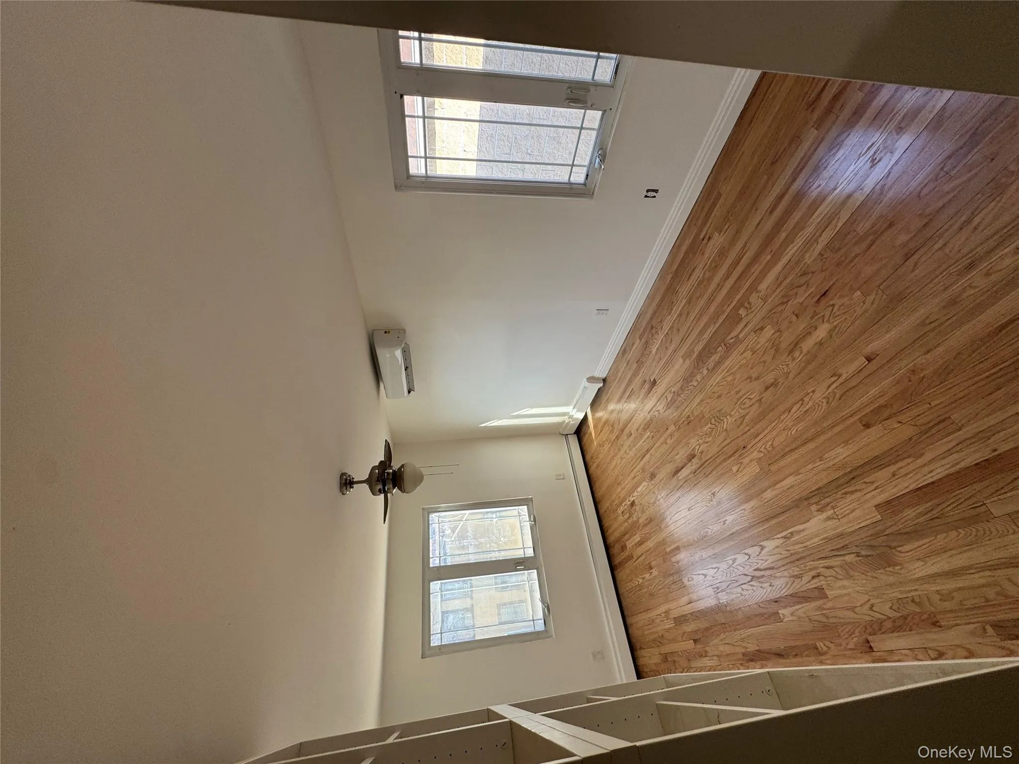 Empty room featuring plenty of natural light, light wood-type flooring, and a ceiling fan Empty room featuring plenty of natural light, light wood-type flooring, and a ceiling fan