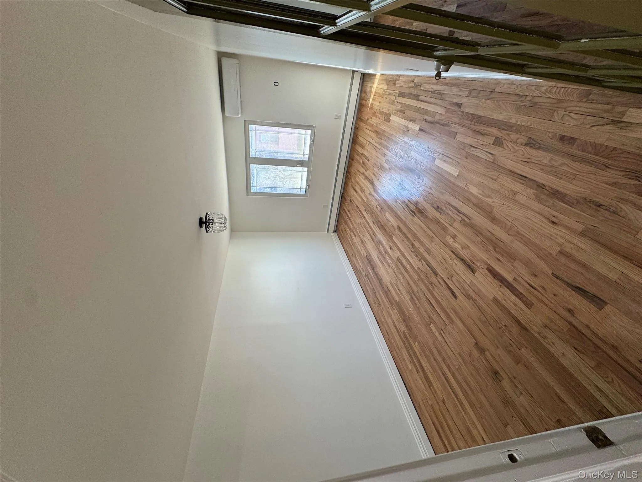 Unfurnished room featuring light wood finished floors, a baseboard heating unit, and a wall mounted AC Unfurnished room featuring light wood finished floors, a baseboard heating unit, and a wall mounted AC