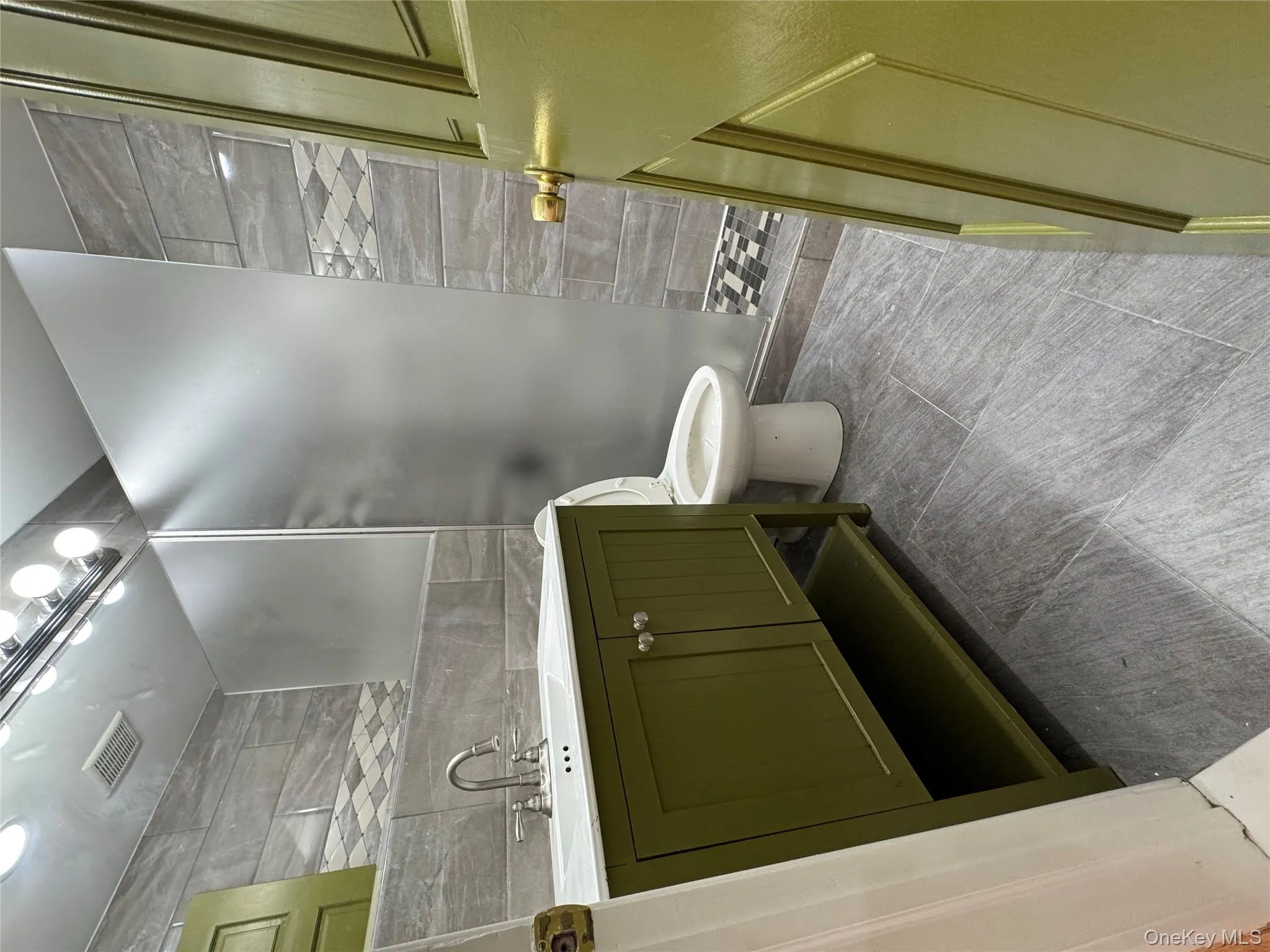 Full bathroom featuring tile walls, vanity, and walk in shower Full bathroom featuring tile walls, vanity, and walk in shower