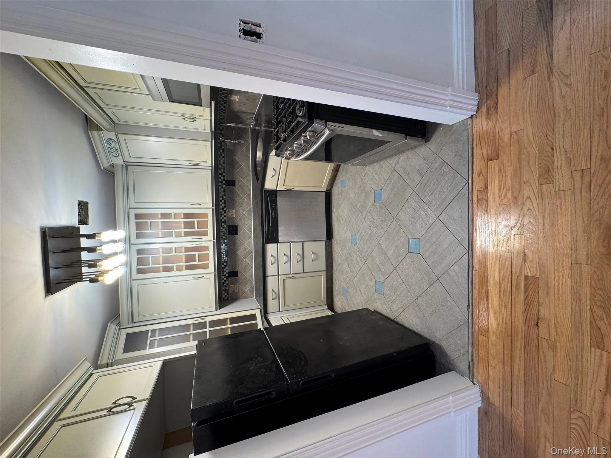 Kitchen with dark countertops, refrigerator, range, dishwasher, and light wood-type flooring Kitchen with dark countertops, refrigerator, range, dishwasher, and light wood-type flooring