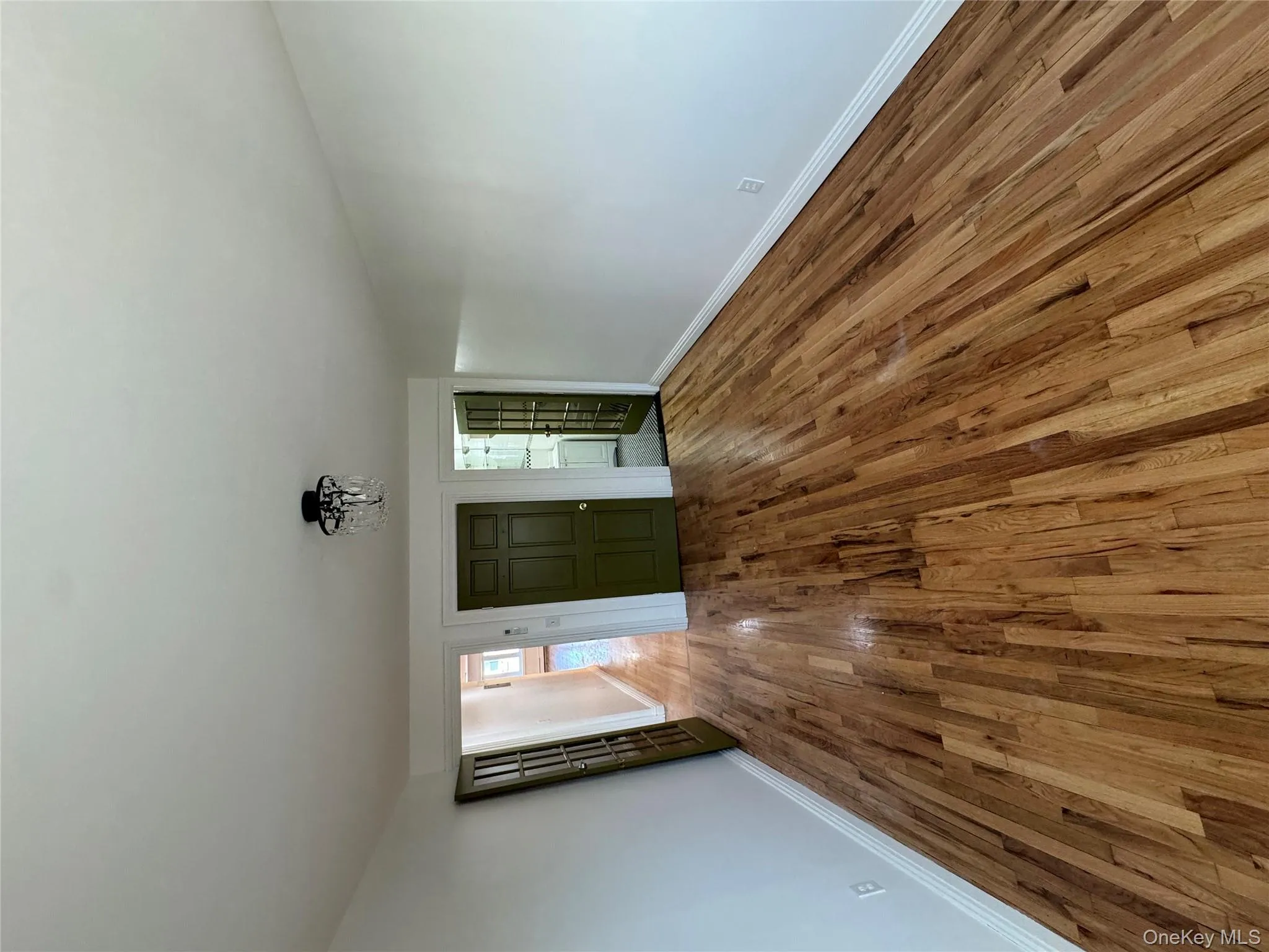 Unfurnished living room with hardwood / wood-style flooring and baseboards Unfurnished living room with hardwood / wood-style flooring and baseboards