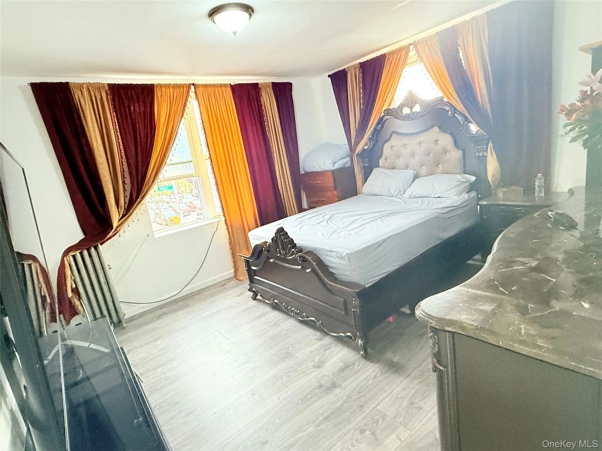 Bedroom featuring multiple windows and light wood-style floors Bedroom featuring multiple windows and light wood-style floors