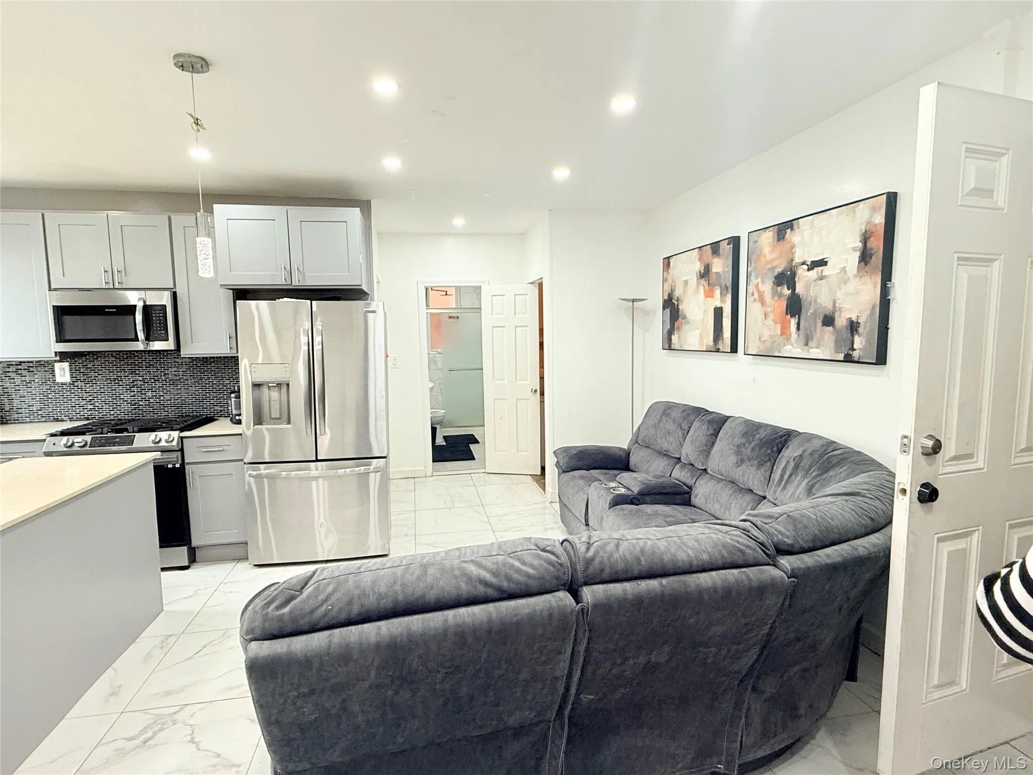 Living area with light marble finish flooring and recessed lighting Living area with light marble finish flooring and recessed lighting