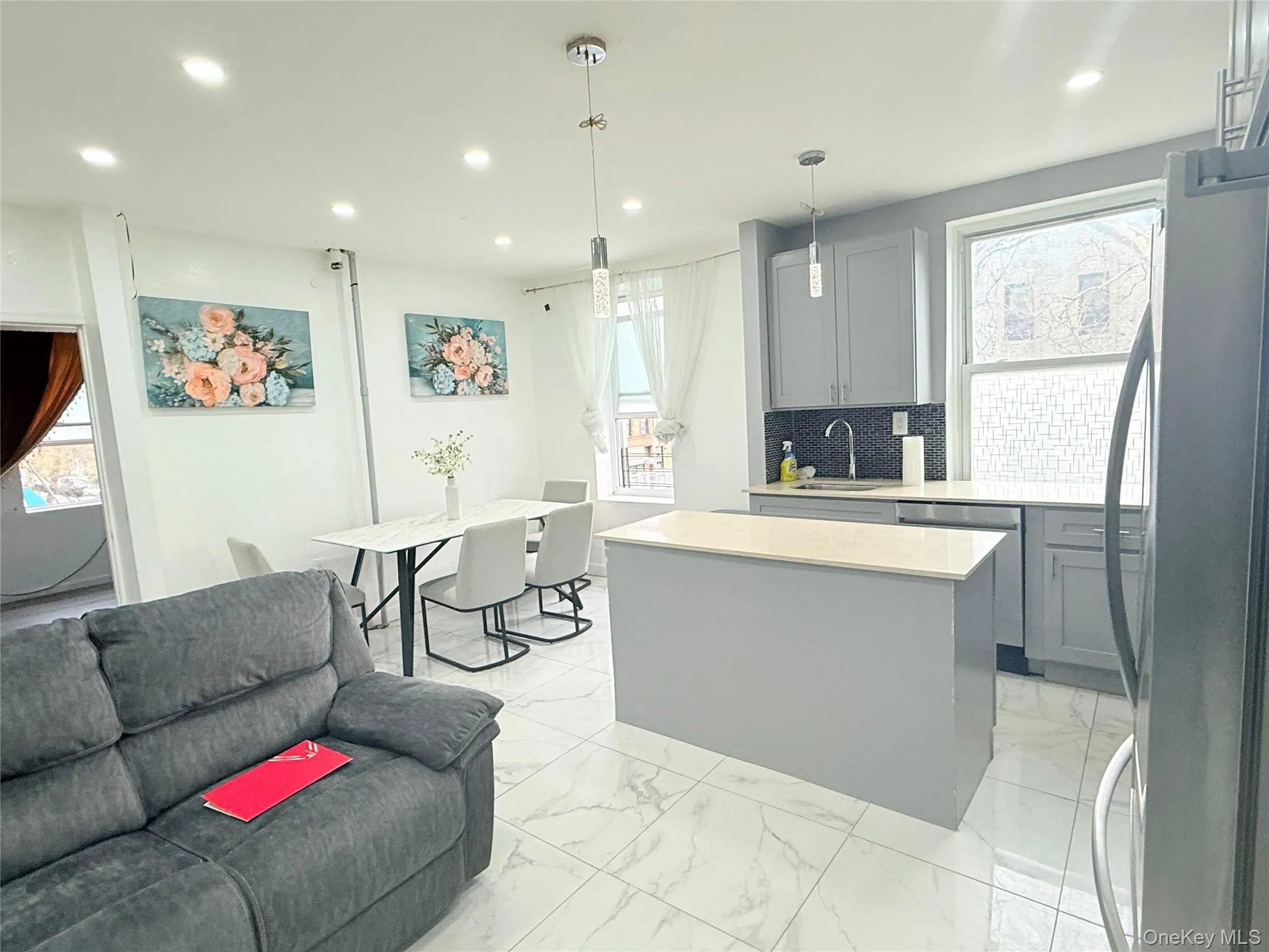 Kitchen with gray cabinetry, stainless steel appliances, light marble finish floors, tasteful backsplash, and recessed lighting Kitchen with gray cabinetry, stainless steel appliances, light marble finish floors, tasteful backsplash, and recessed lighting