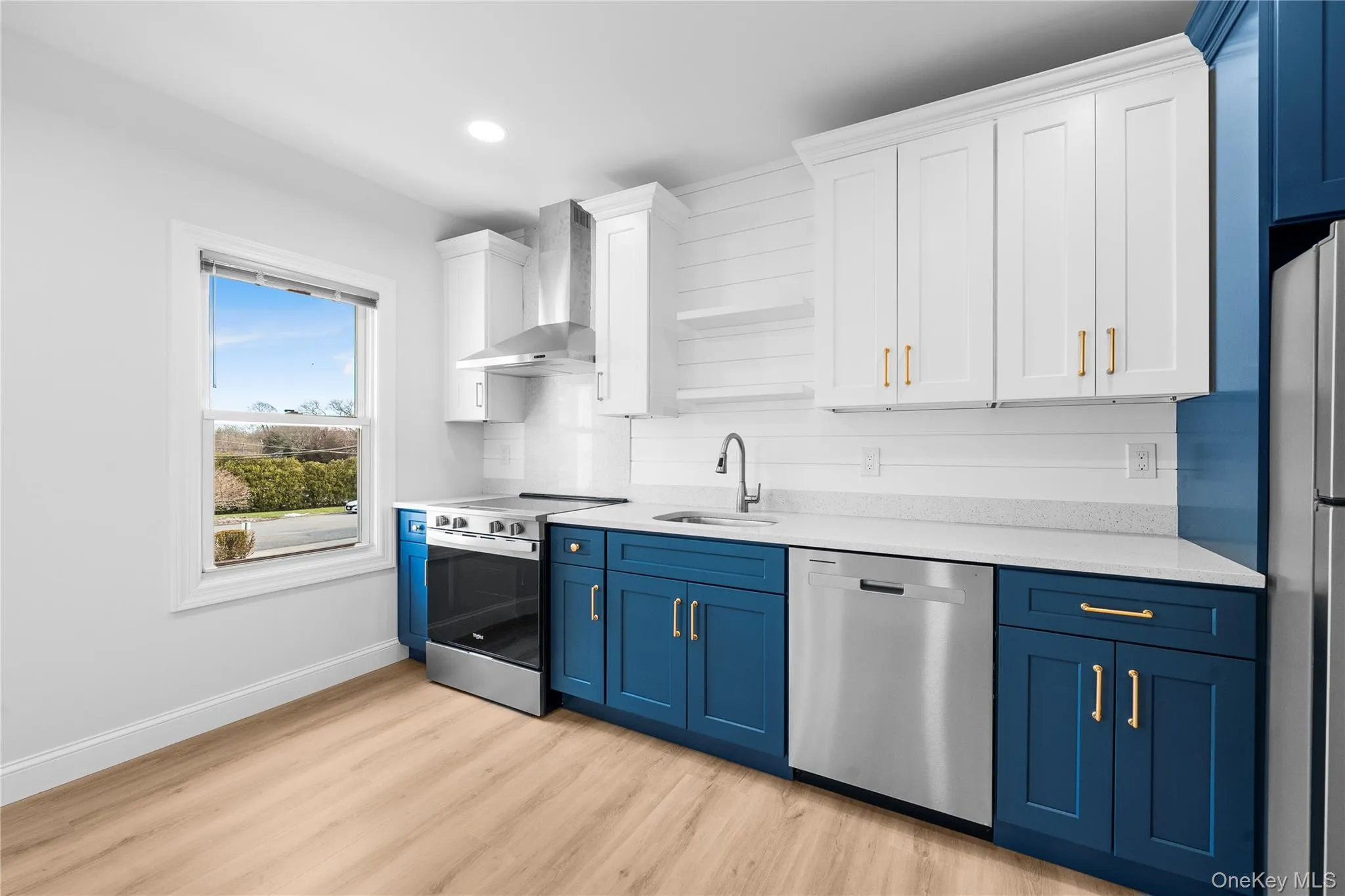 Kitchen with blue cabinets, white cabinetry, appliances with stainless steel finishes, and recessed lighting Kitchen with blue cabinets, white cabinetry, appliances with stainless steel finishes, and recessed lighting
