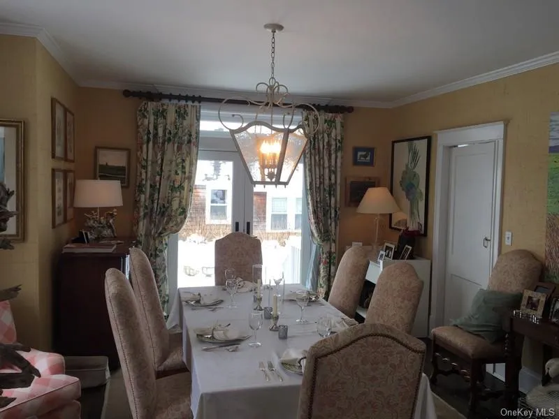 Dining room featuring crown molding, a healthy amount of sunlight, and a notable chandelier Dining room featuring crown molding, a healthy amount of sunlight, and a notable chandelier