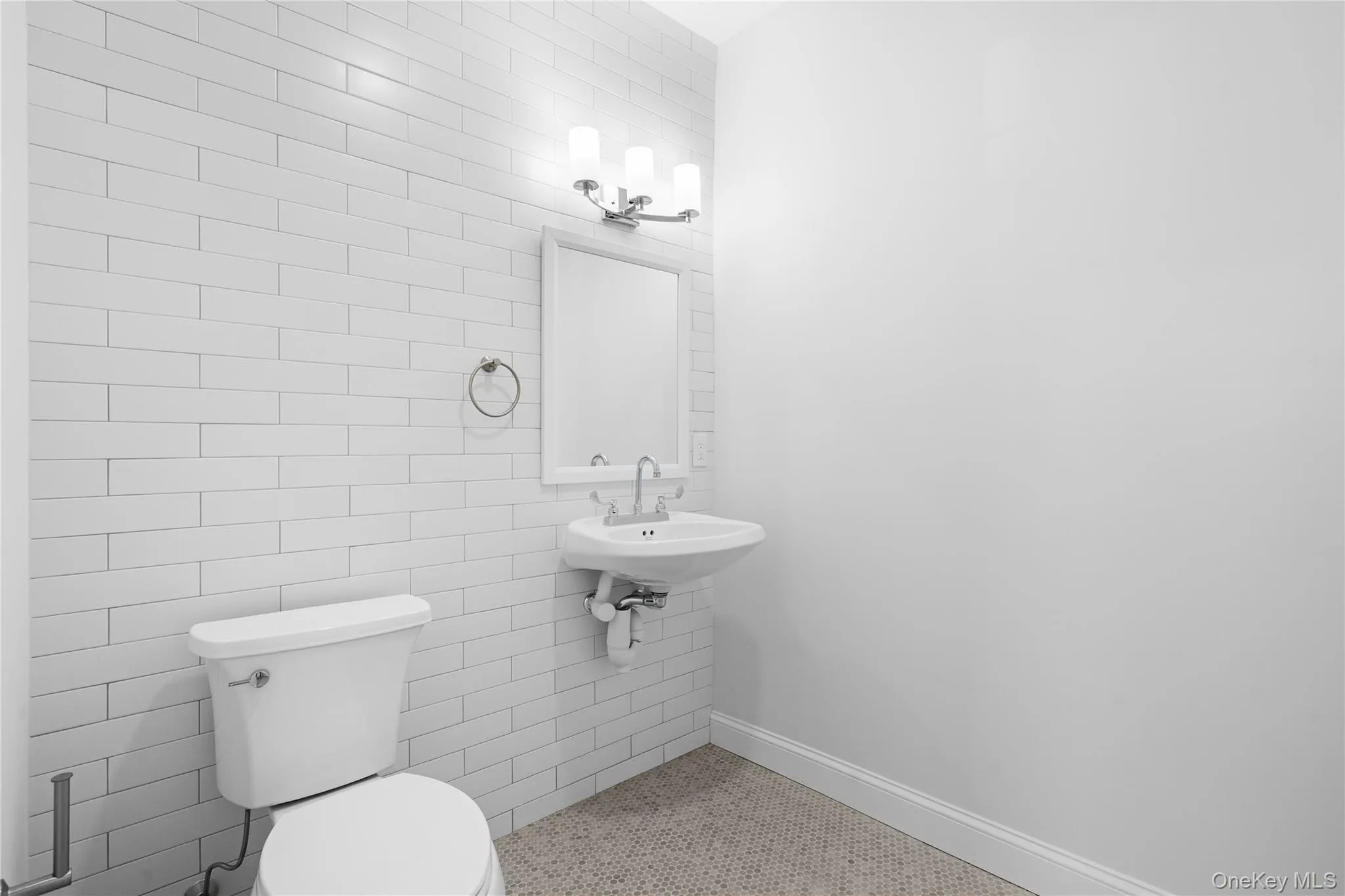 Half bathroom featuring baseboards and tile walls Half bathroom featuring baseboards and tile walls