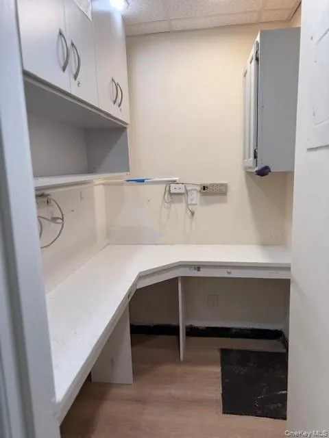 Unfurnished office featuring a paneled ceiling and light wood-style flooring Unfurnished office featuring a paneled ceiling and light wood-style flooring