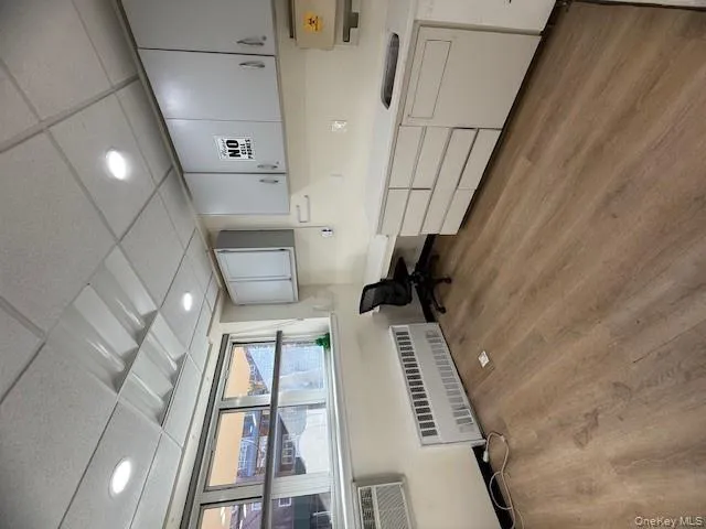 Home office featuring a paneled ceiling, radiator, light wood-type flooring, and recessed lighting Home office featuring a paneled ceiling, radiator, light wood-type flooring, and recessed lighting