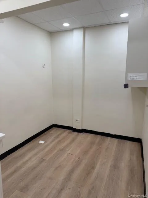 Spare room with light wood-type flooring and a drop ceiling Spare room with light wood-type flooring and a drop ceiling