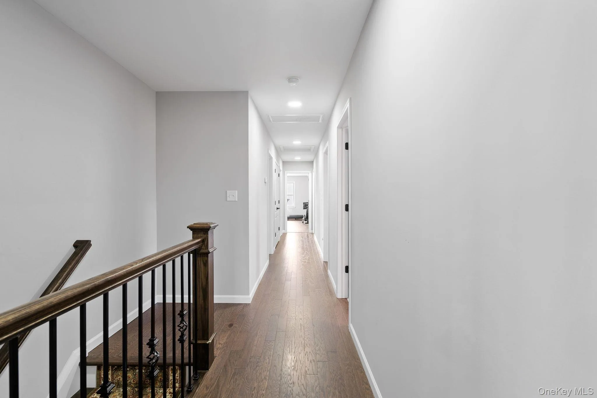 Hall featuring an upstairs landing, recessed lighting, and dark wood-style flooring Hall featuring an upstairs landing, recessed lighting, and dark wood-style flooring