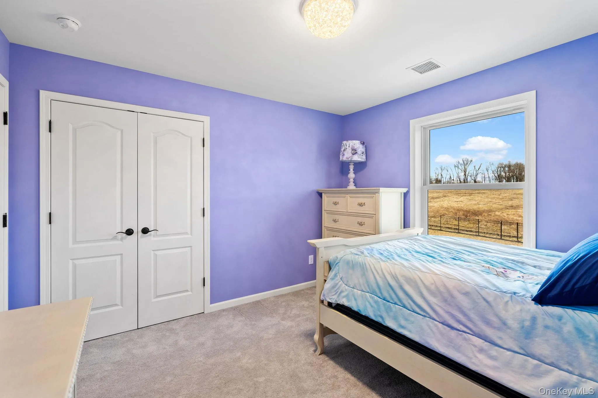 Bedroom featuring a closet and light colored carpet Bedroom featuring a closet and light colored carpet