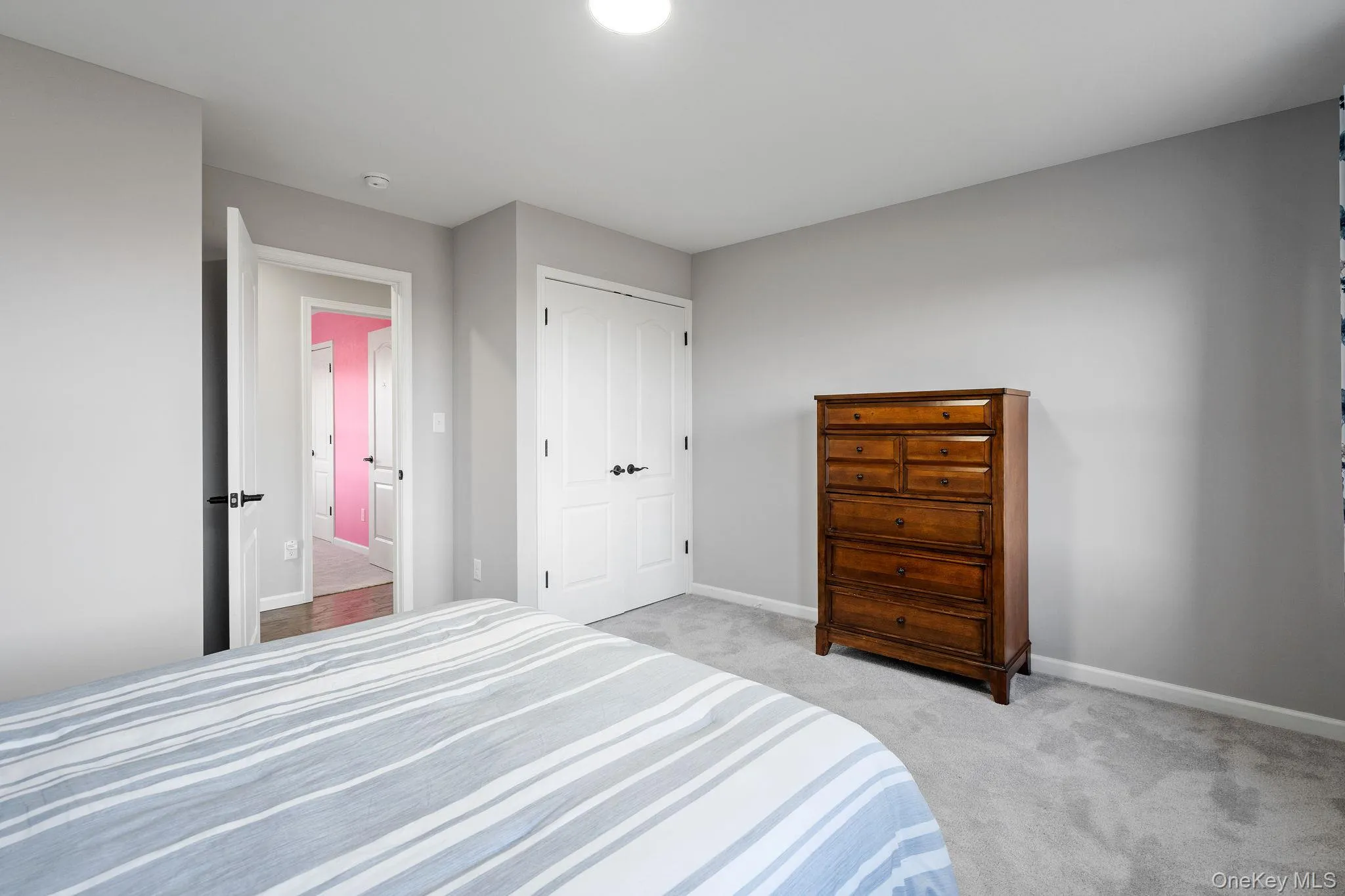 Bedroom with light carpet and a closet Bedroom with light carpet and a closet