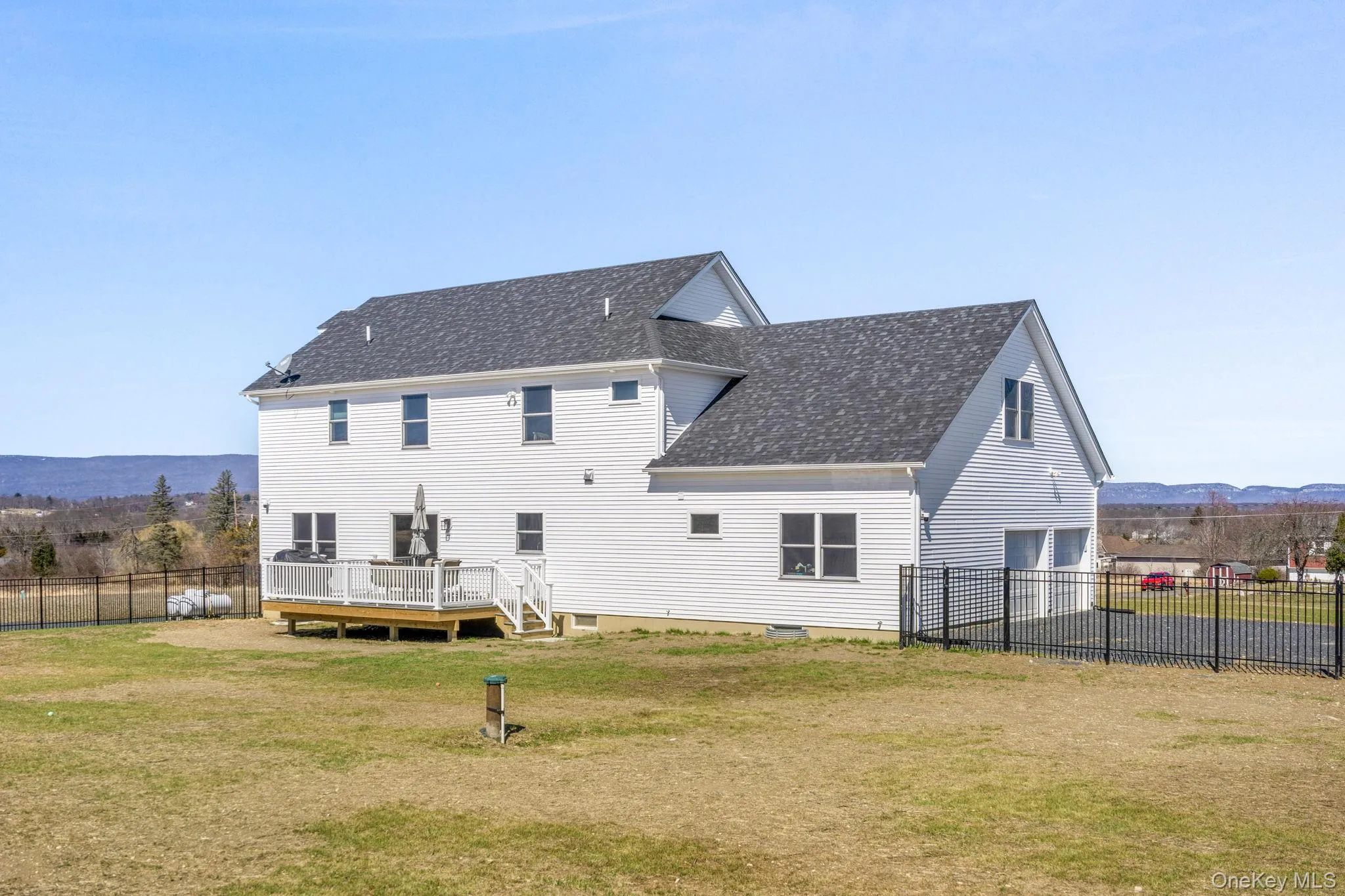 Rear view of property with a deck with mountain view and a shingled roof Rear view of property with a deck with mountain view and a shingled roof